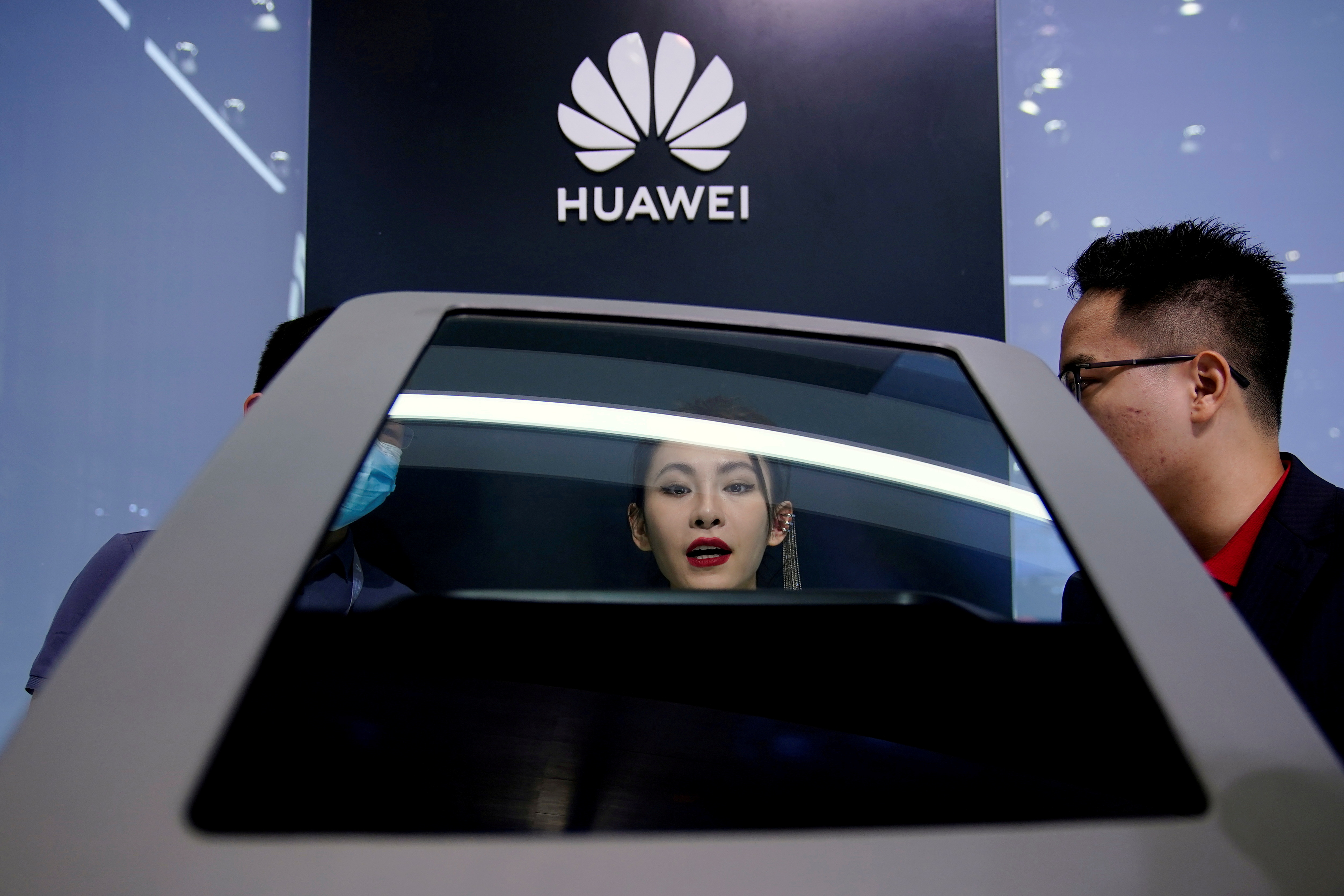 People check a display near a Huawei logo during a media day for the Auto Shanghai show in Shanghai, China April 19, 2021. REUTERS/Aly Song/File Photo