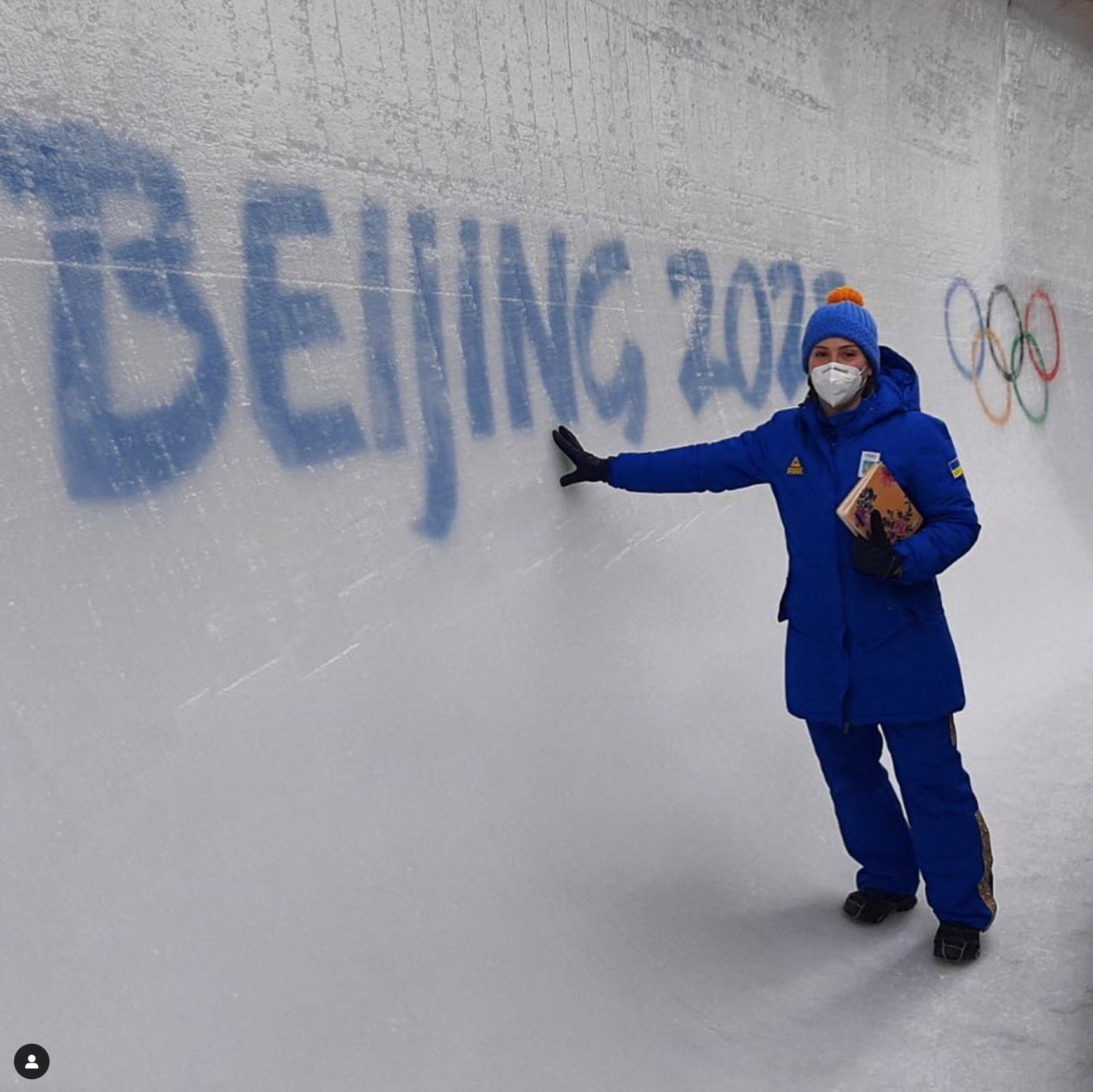 Ukrainian bobsledder, Lidiia Hunko, poses on ice next to a sign reading 
