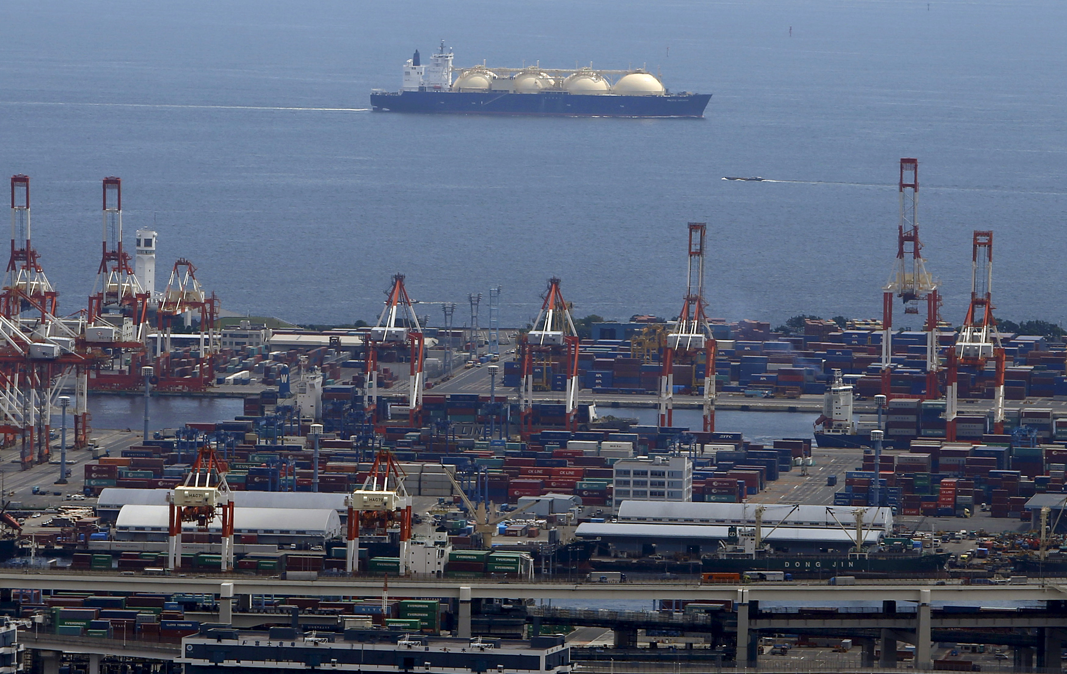 A LNG (Liquefied Natural Gas) tanker is seen behind a port in Yokohama, south of Tokyo, Japan, September 4, 2015. REUTERS/Yuya Shino