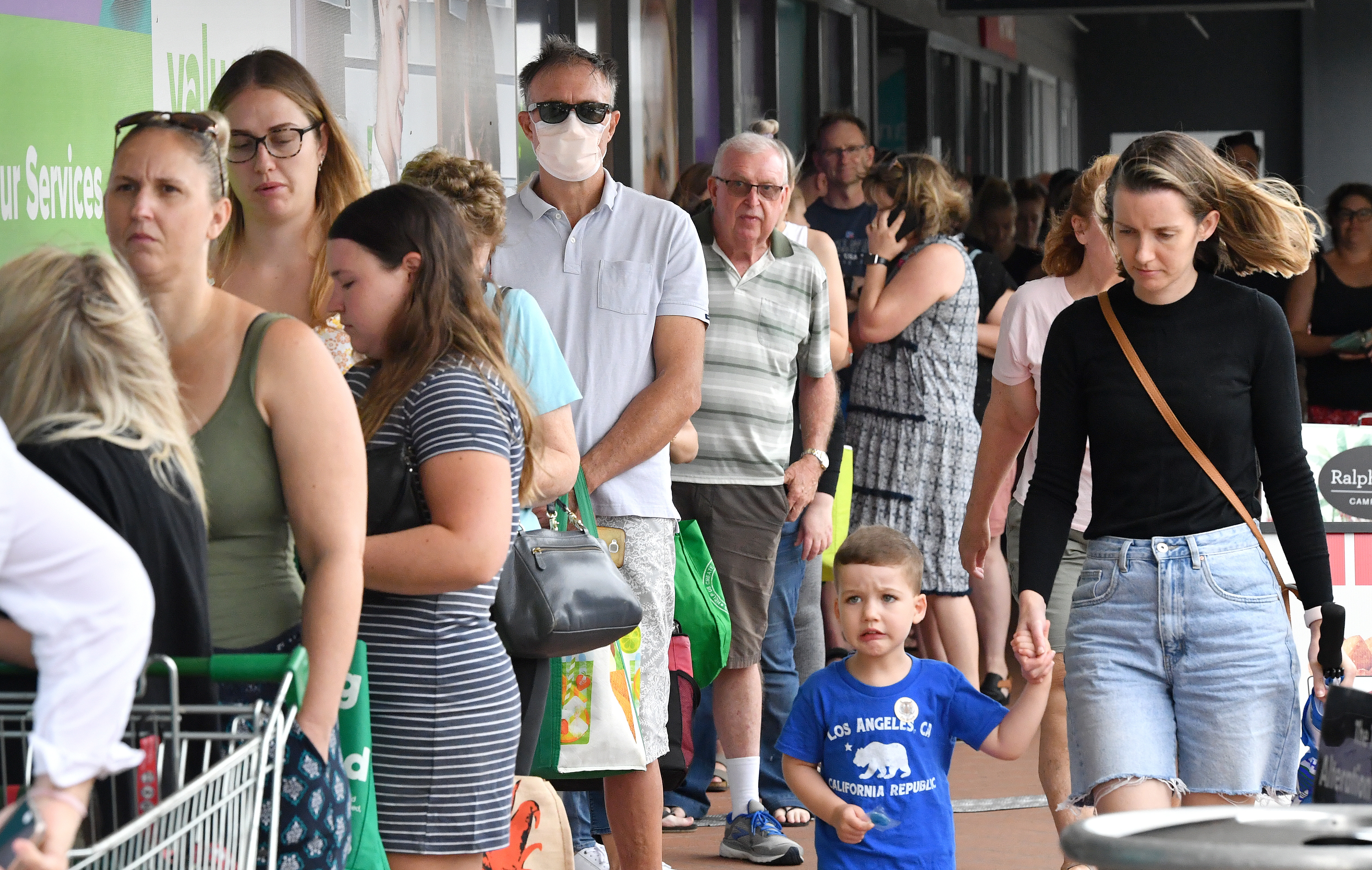 People line up to enter a grocery store before an impending lockdown in Brisbane