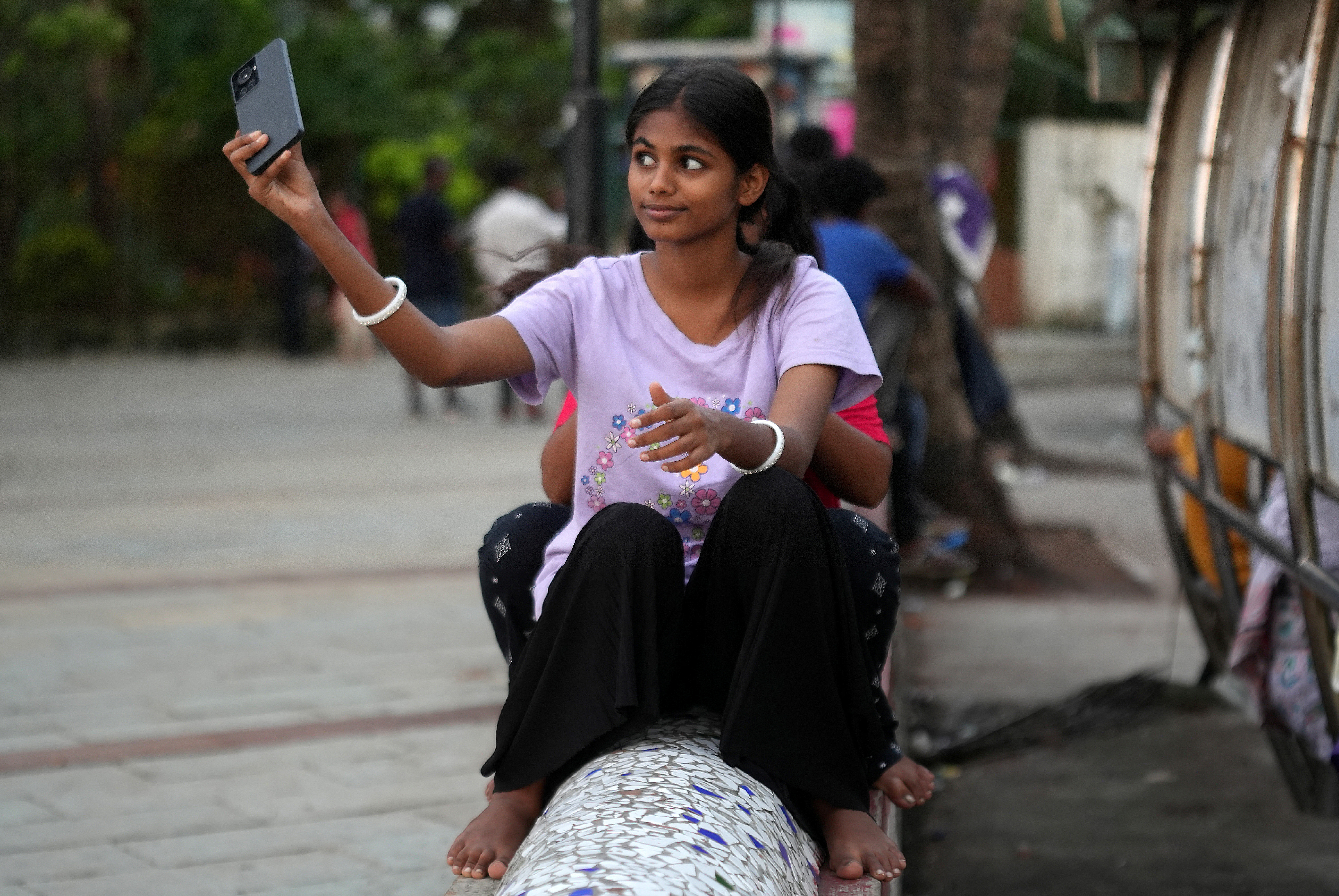 Maleesha Kharwa takes a selfie next to a bus terminal in Mumbai