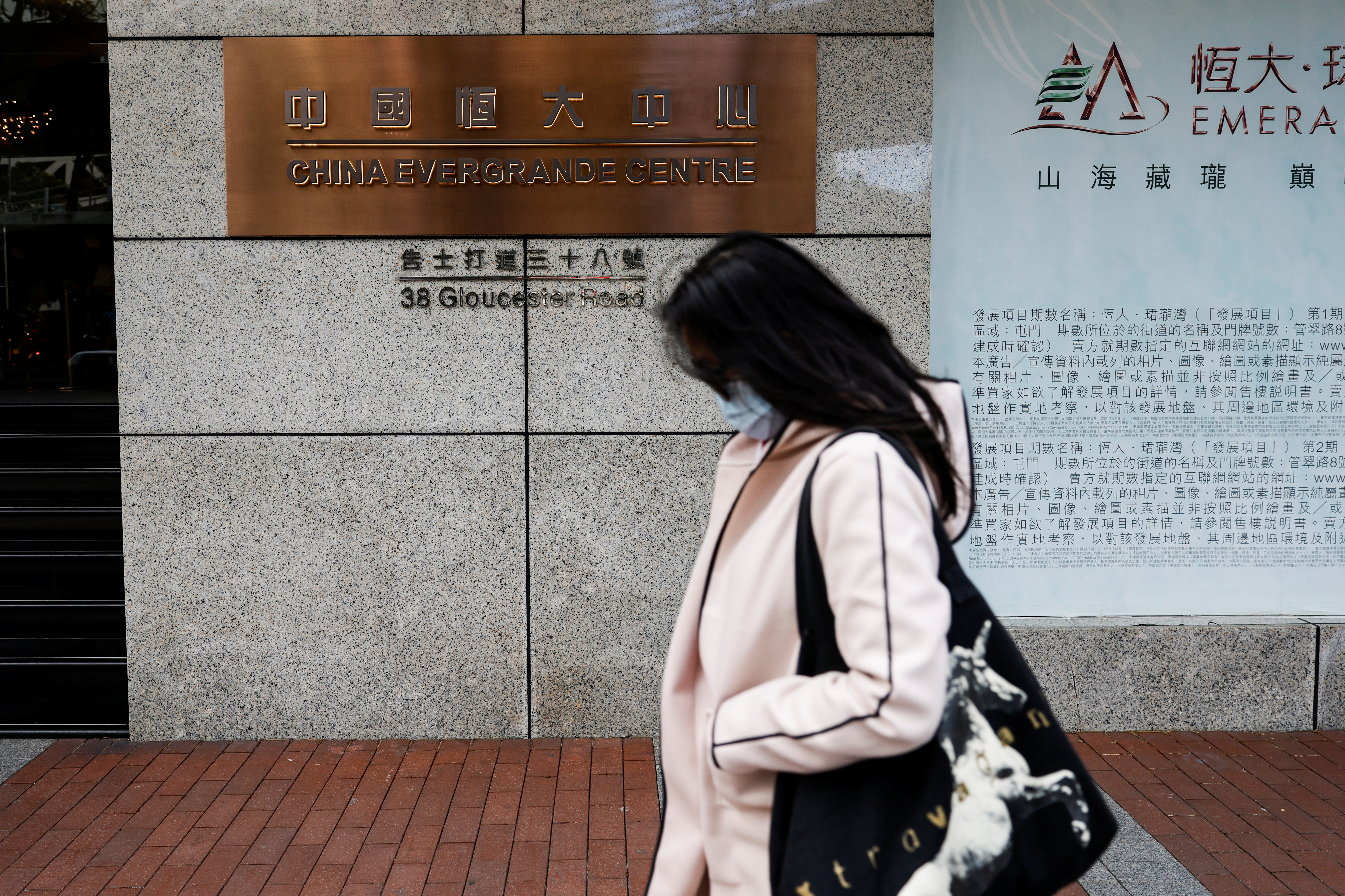 A woman walks in front of the China Evergrande Centre building sign in Hong Kong