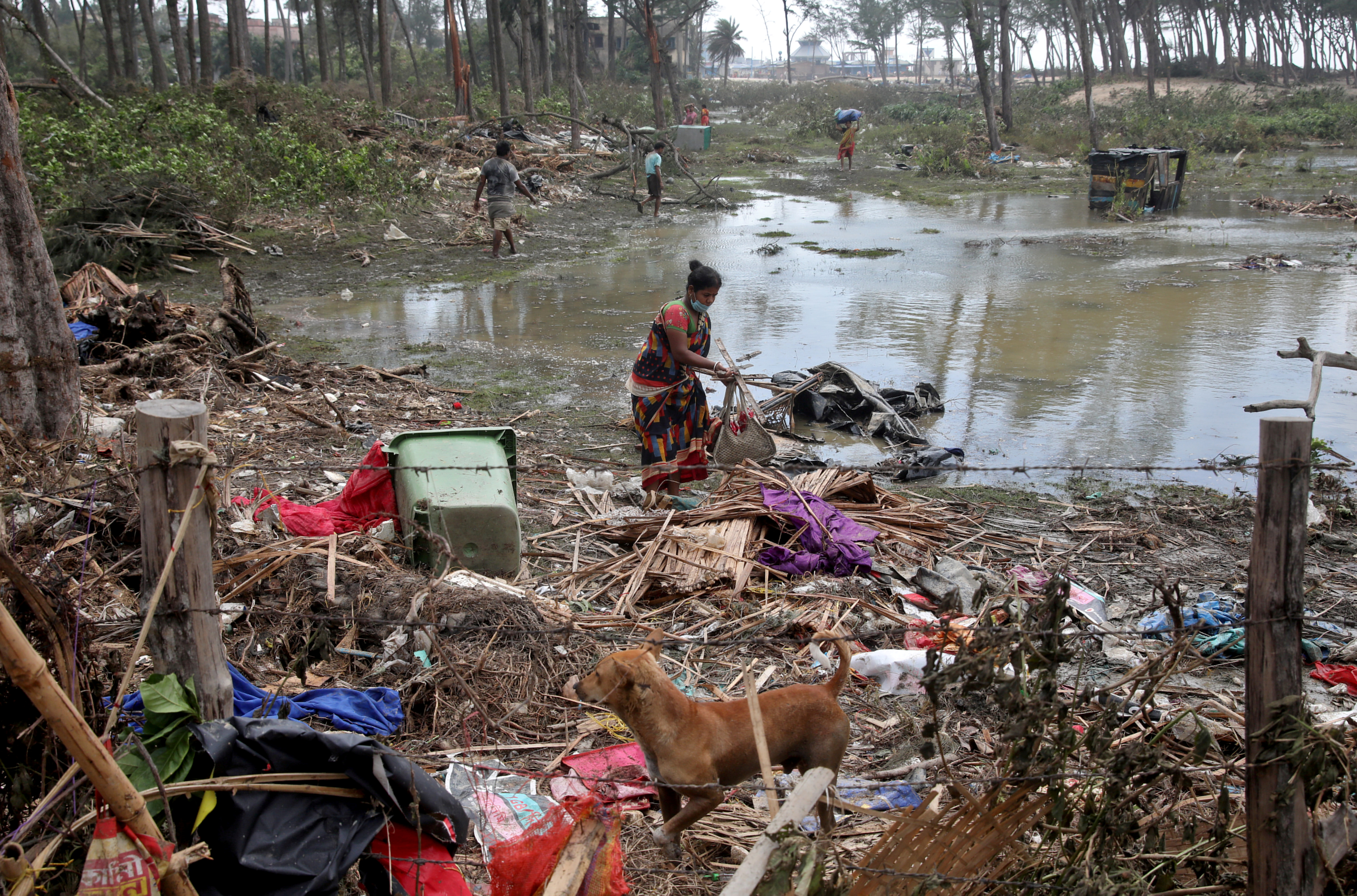 A woman salvages her belongings near her damaged hut following Cyclone Yaas in Digha, Purba Medinipur district in the eastern state of West Bengal, India, May 27, 2021. REUTERS/Rupak De Chowdhuri