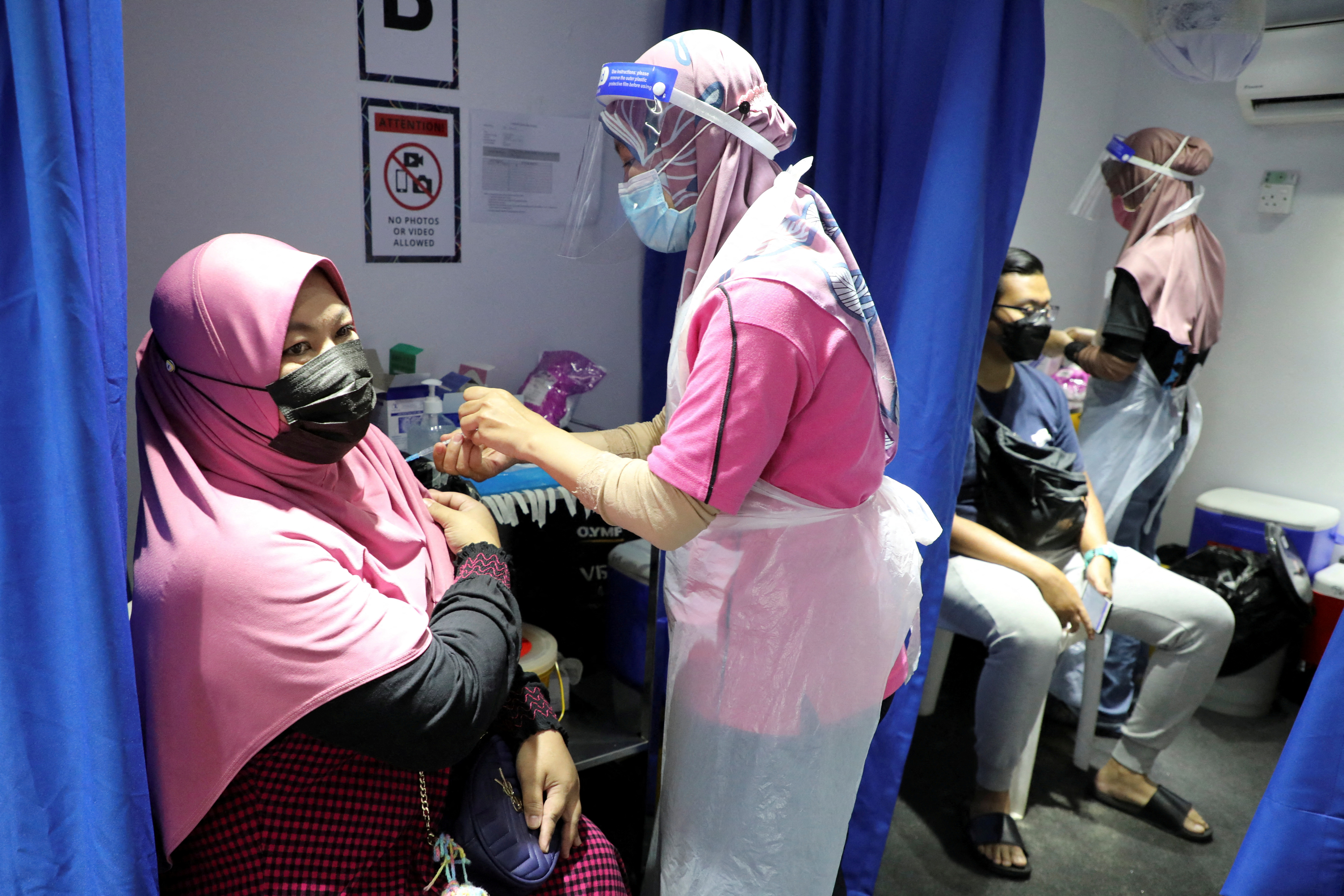 People receive COVID-19 vaccine in a vaccination truck in Kuala Lumpur