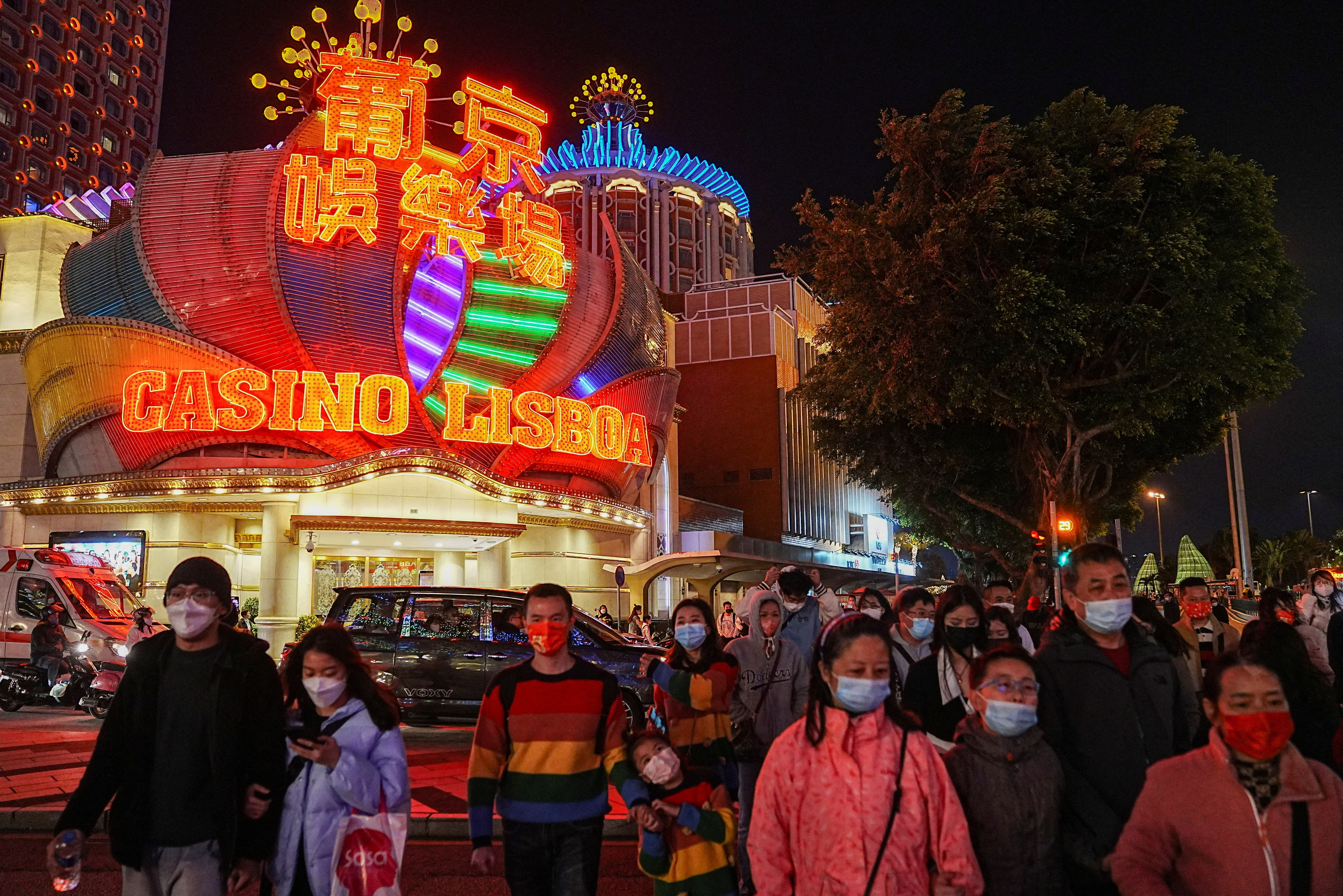 Visitors walk past the Casino Lisboa operated by SJM Holdings during Lunar New Year in Macau