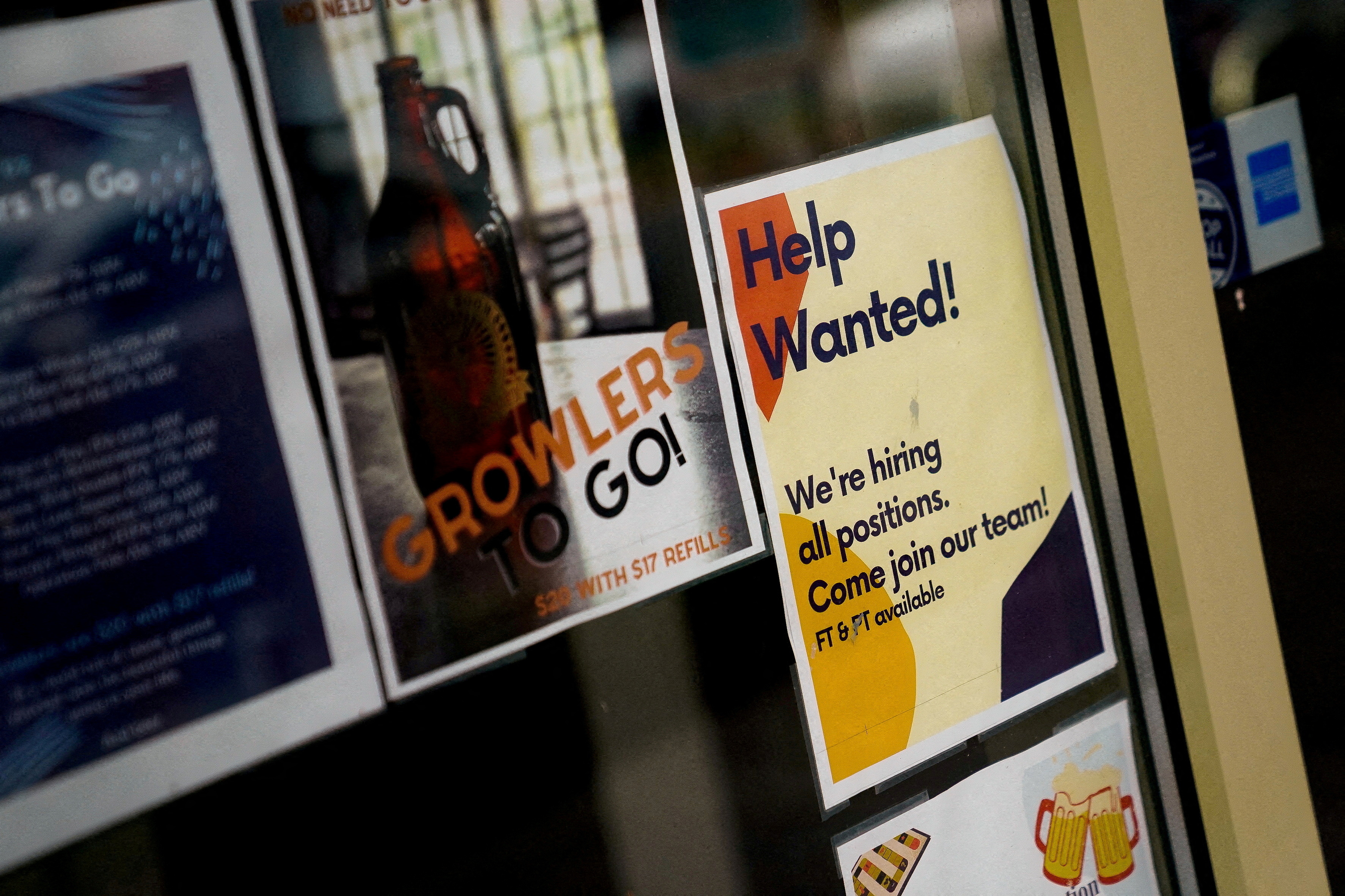 An employee hiring sign is seen in a window of a business in Arlington