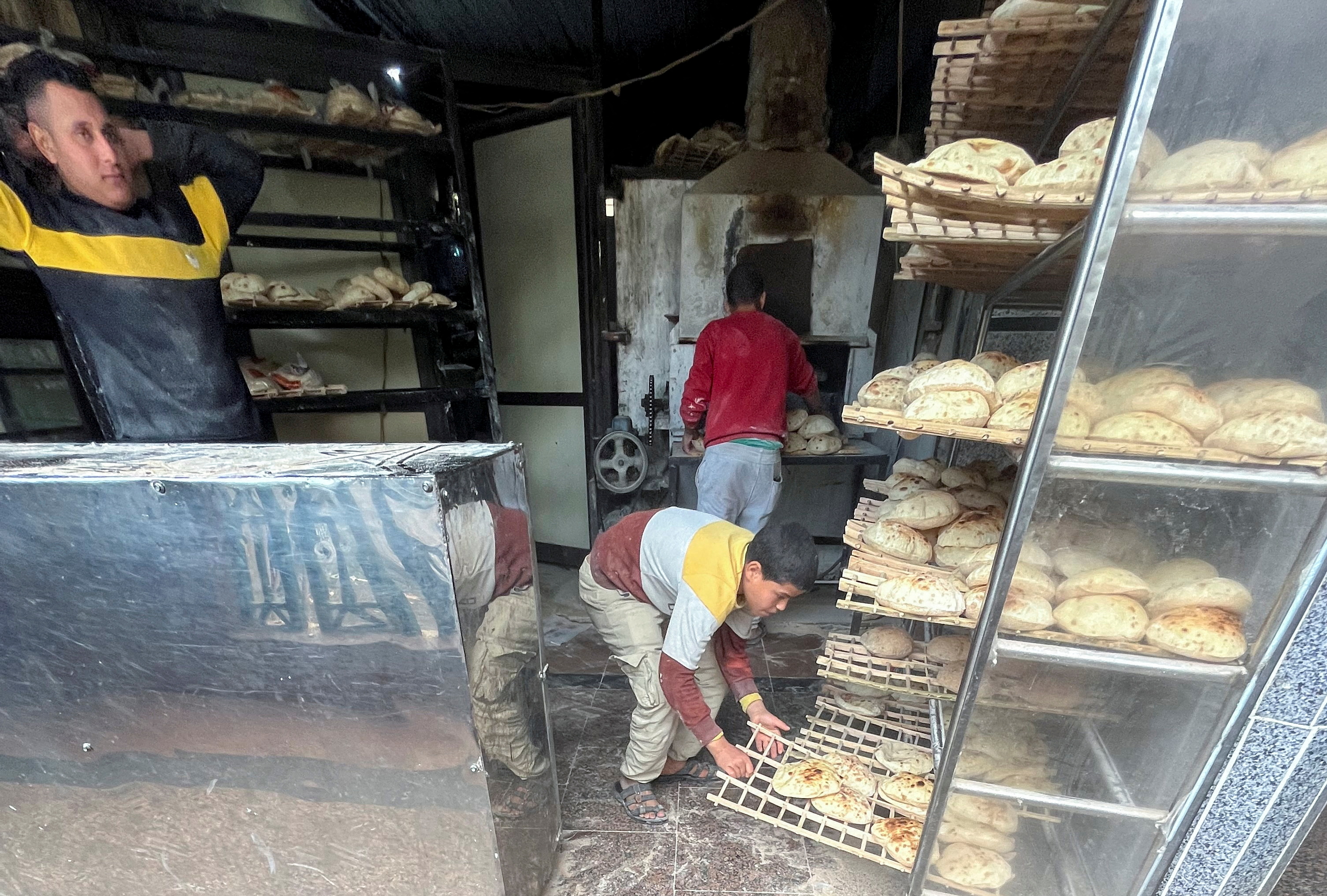 Employees arrange bread for sale at a bakery in Maadi, a suburb of Cairo