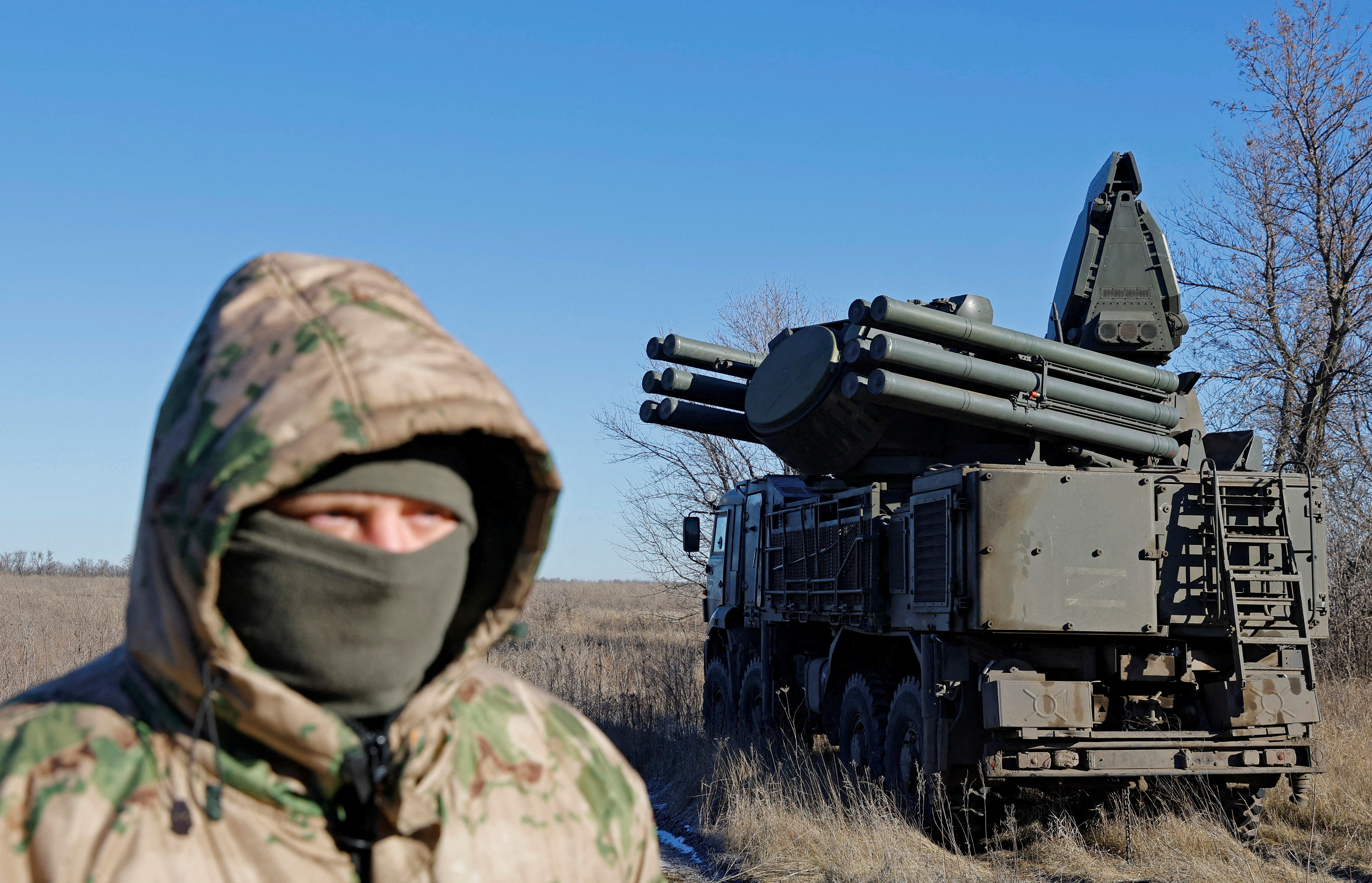 A Russian service member stands in front of a Pantsir anti-aircraft missile system on combat duty in the Luhansk region