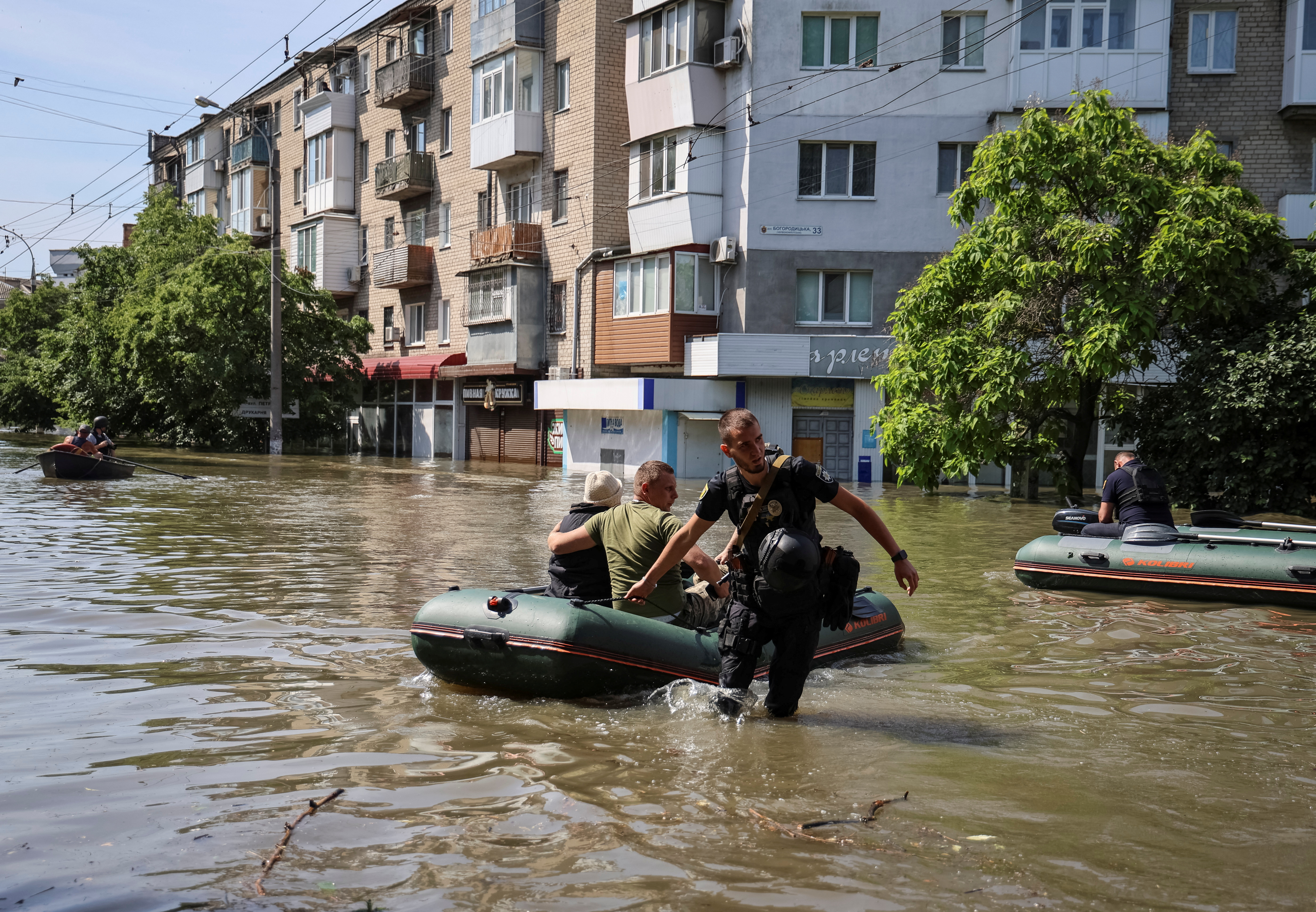 Police evacuate local residents from a flooded area after the Nova Kakhovka dam breached, in Kherson