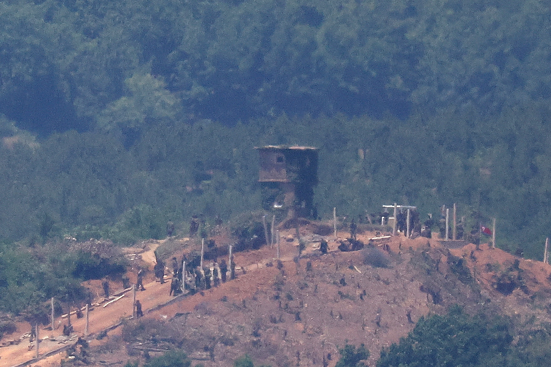 North Korean people work on a military fence near their guard post at the inter-Korean border