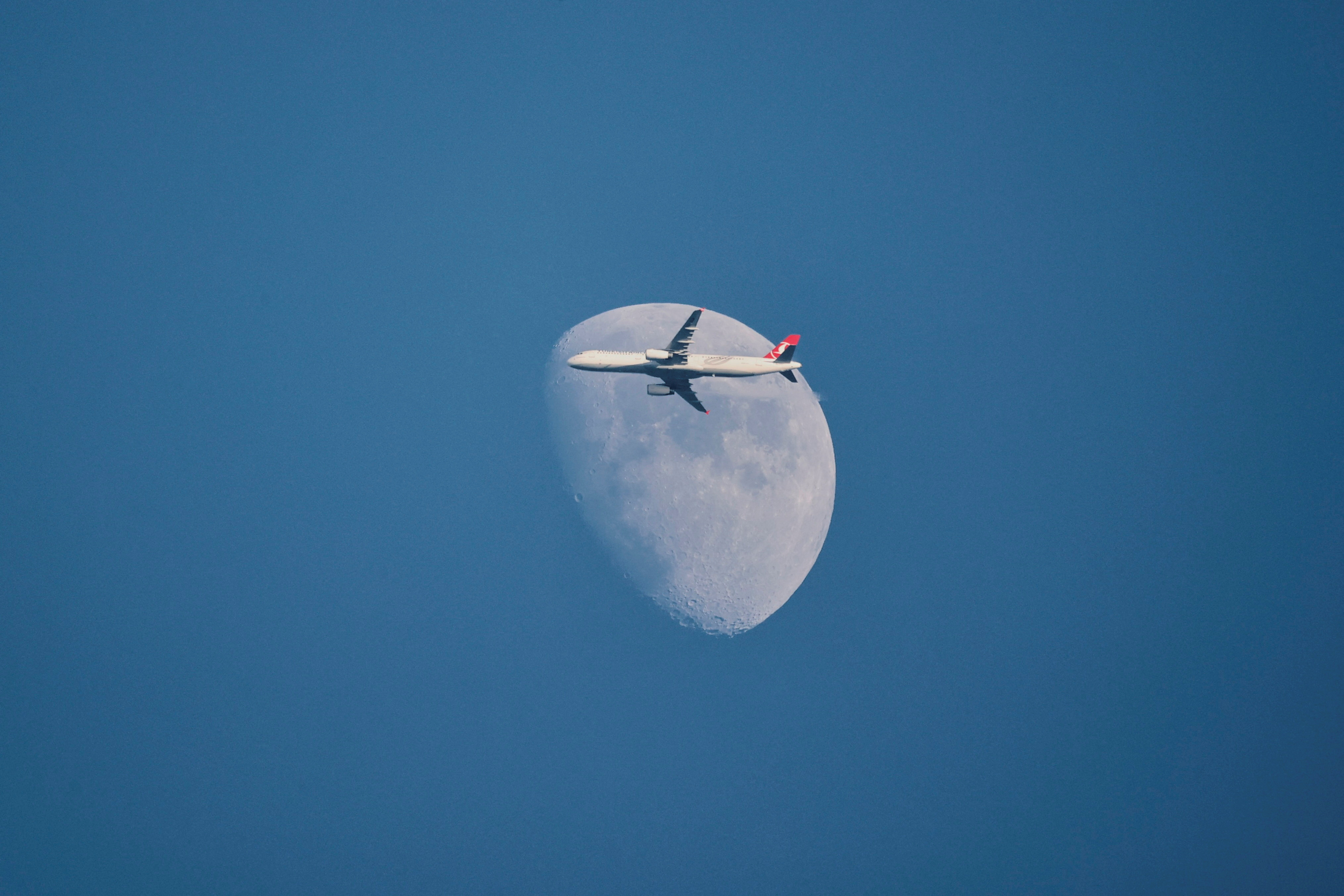 A Turkish Airlines Airbus A321-231 aircraft flies past the moon as it descends for Istanbul Airport
