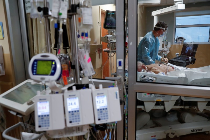 A critical care respiratory therapist works with a coronavirus disease (COVID-19) positive patient in the intensive care unit (ICU) at Sarasota Memorial Hospital in Sarasota, Florida
