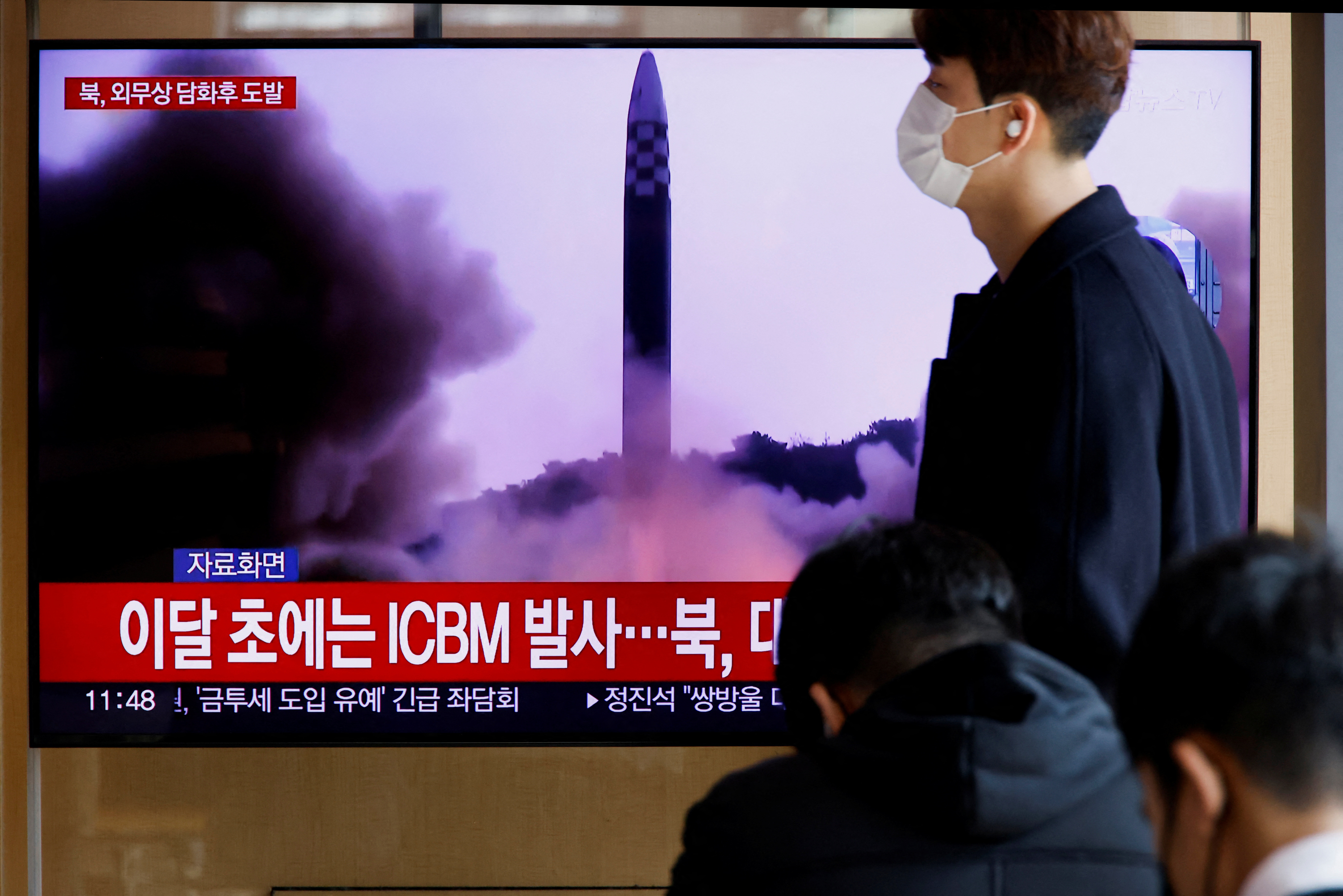 A man walks past a TV broadcasting a news report, on North Korea firing a ballistic missile off its east coast, in Seoul