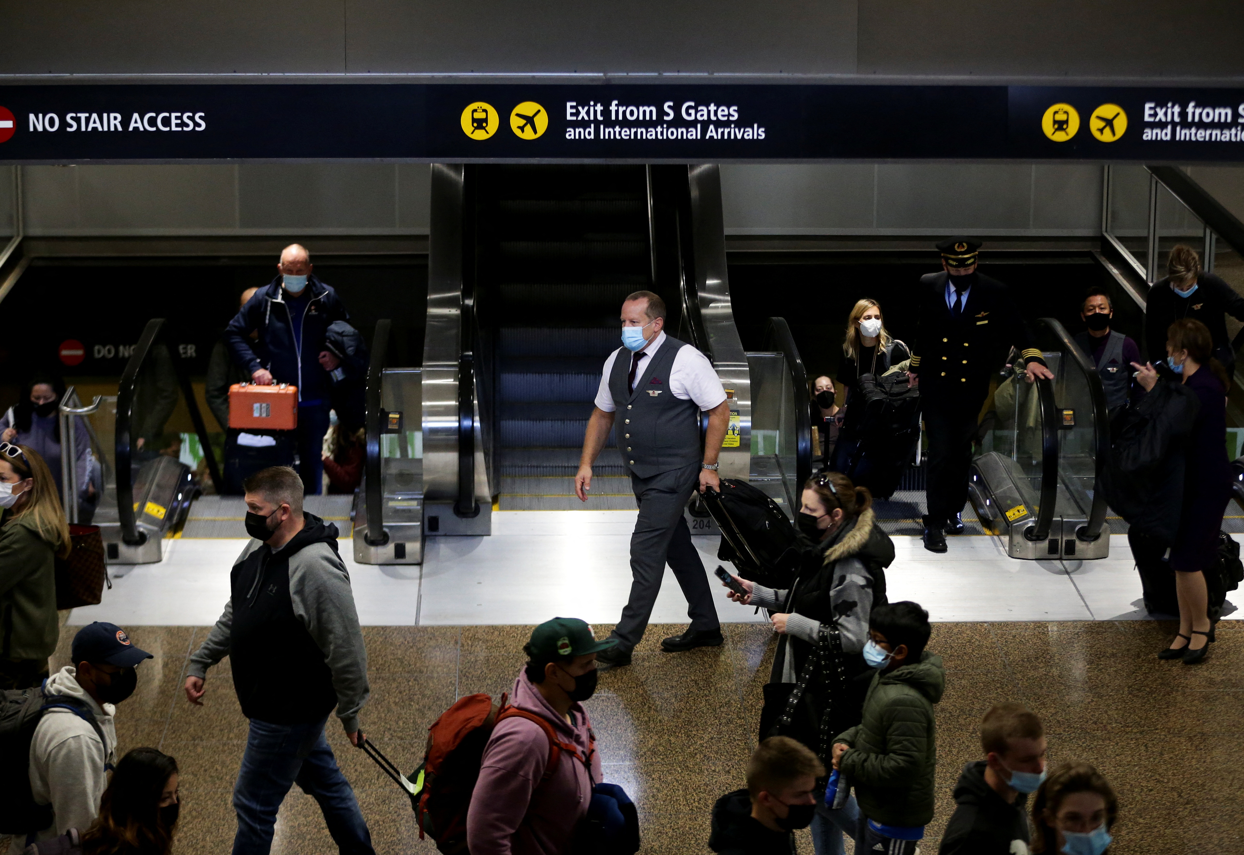 People enter the baggage claim area from the international arrivals terminal as the U.S. reopens air and land borders to coronavirus disease (COVID-19) vaccinated travellers for the first time since the COVID-19 restrictions were imposed, at Sea-Tac Airport in Seattle, Washington, U.S. November 8, 2021.  REUTERS/Lindsey Wasson