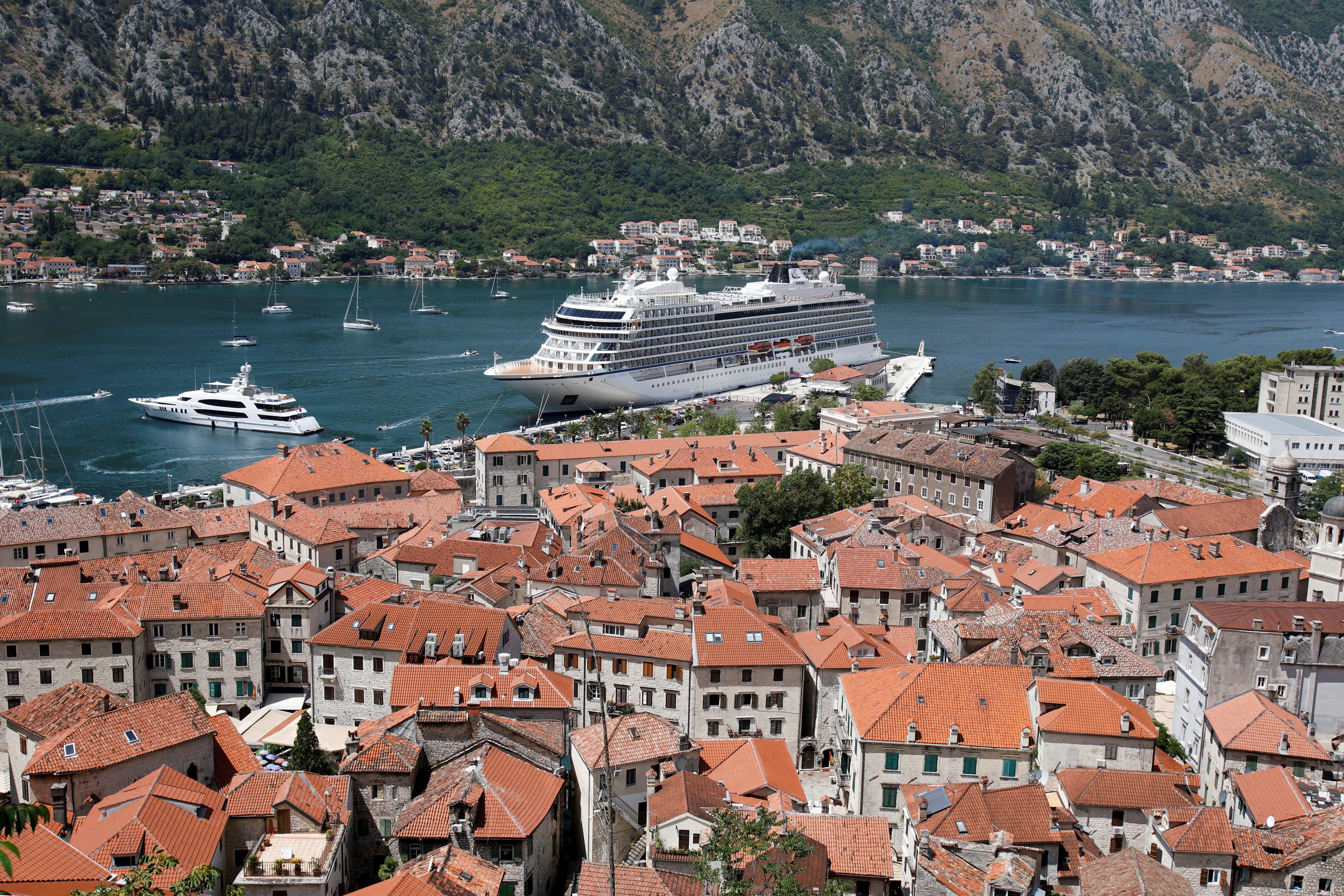 Norwegian mega cruise ship is docked in front of Old Town of Kotor