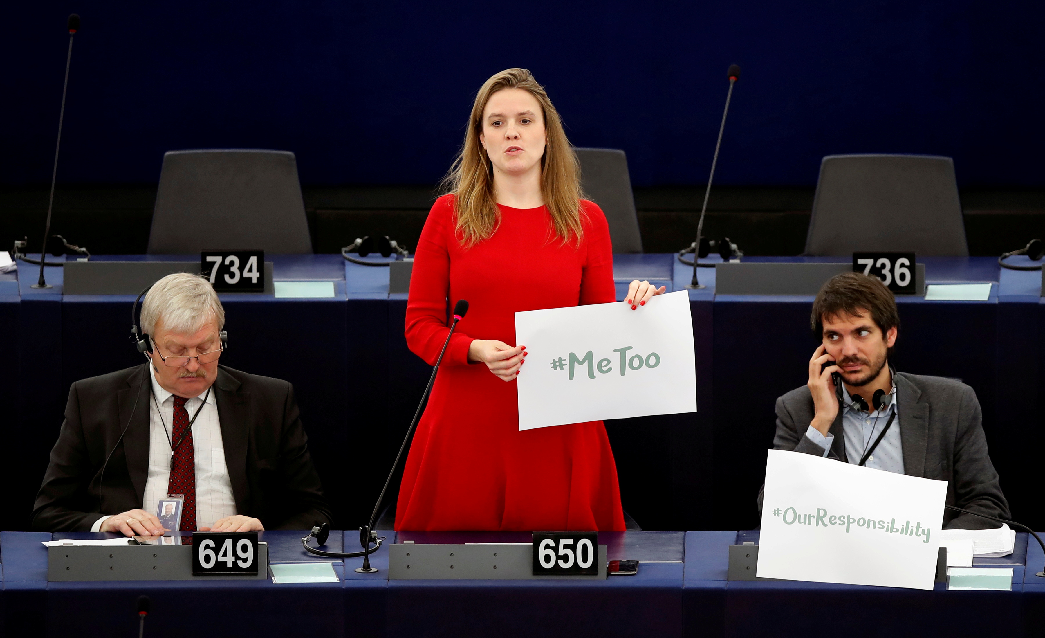 European Parliament member Terry Reintke holds a placard with the hashtag 