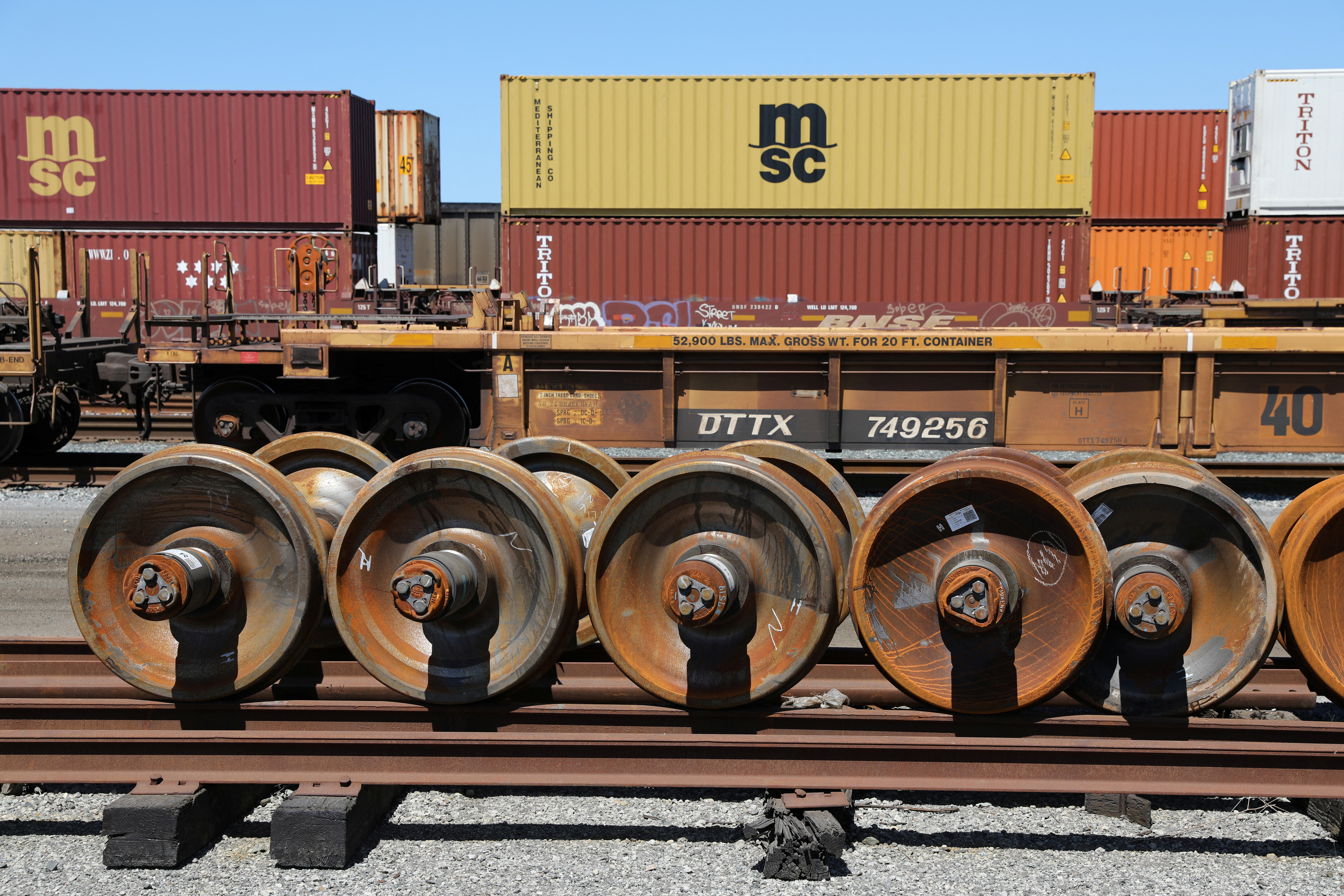 Train wheels are stored next to shipping containers on rail cars at Roberts Bank Superport in Delta