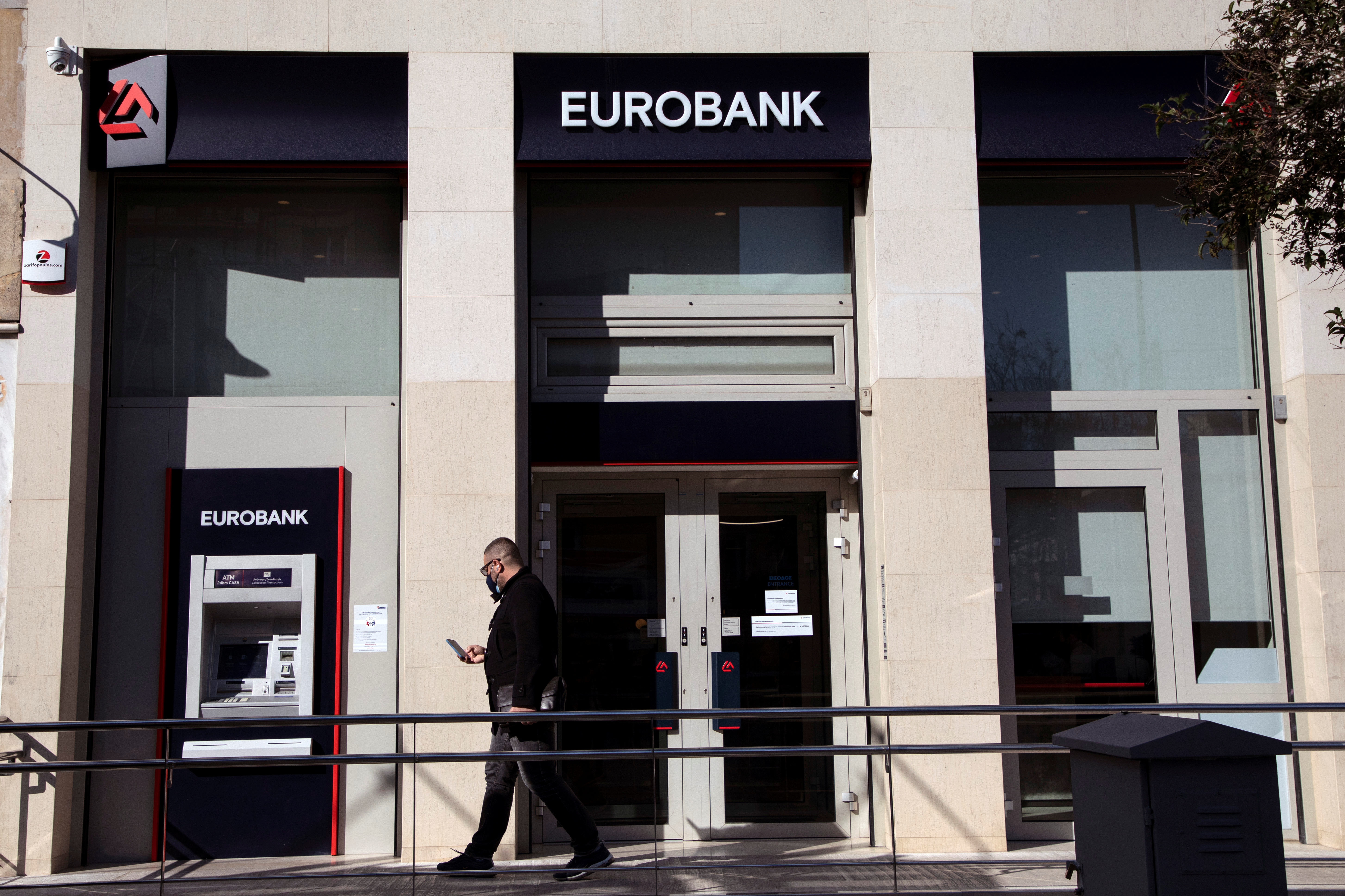 A man walks outside a Eurobank branch in Athens