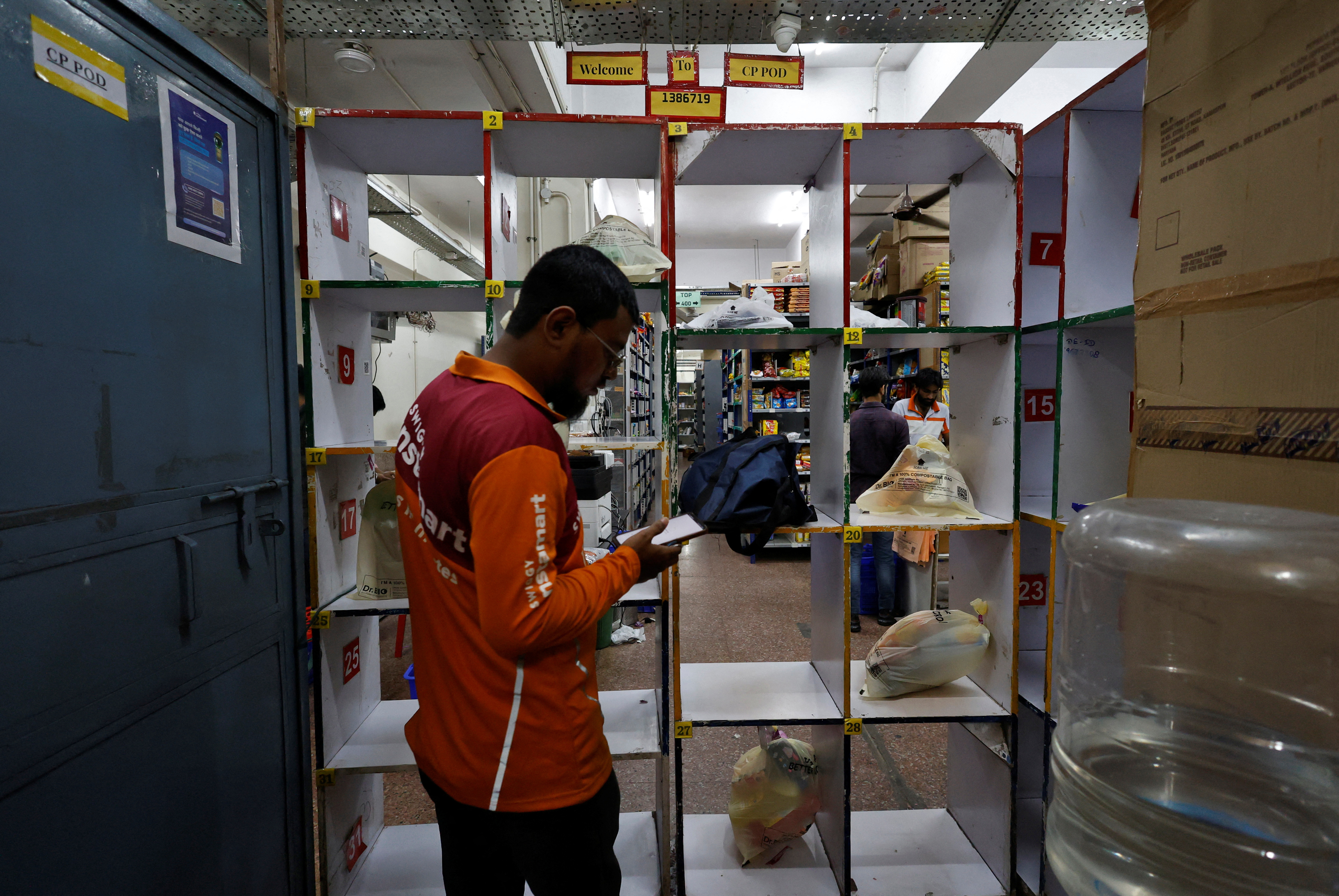 A gig worker picks up groceries for an order from a Swiggy's grocery warehouse, in New Delhi