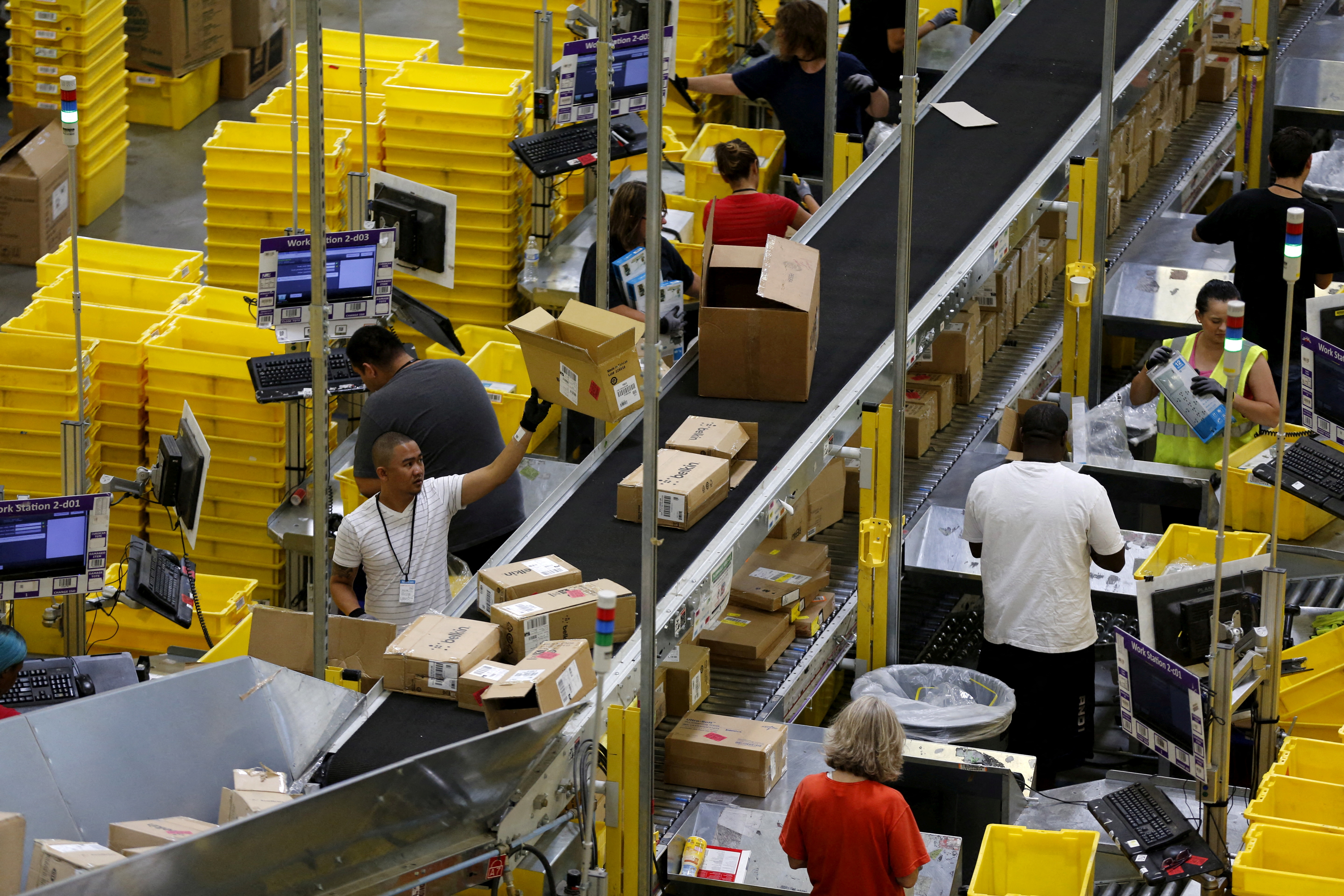 Workers sort arriving products at an Amazon Fulfilment Center in Tracy