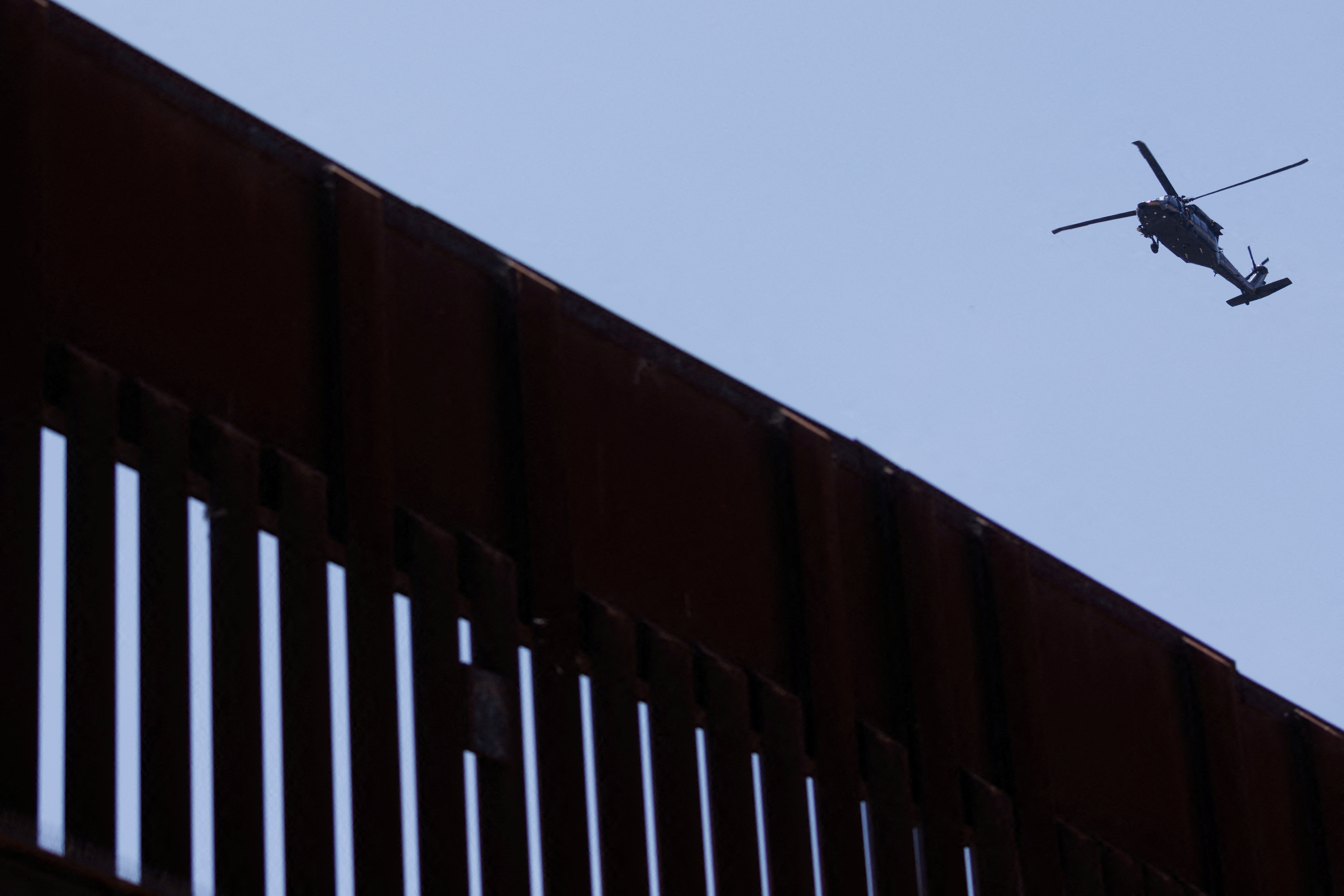 A helicopter from the U.S.border patrol flys along the U.S. Mexico border