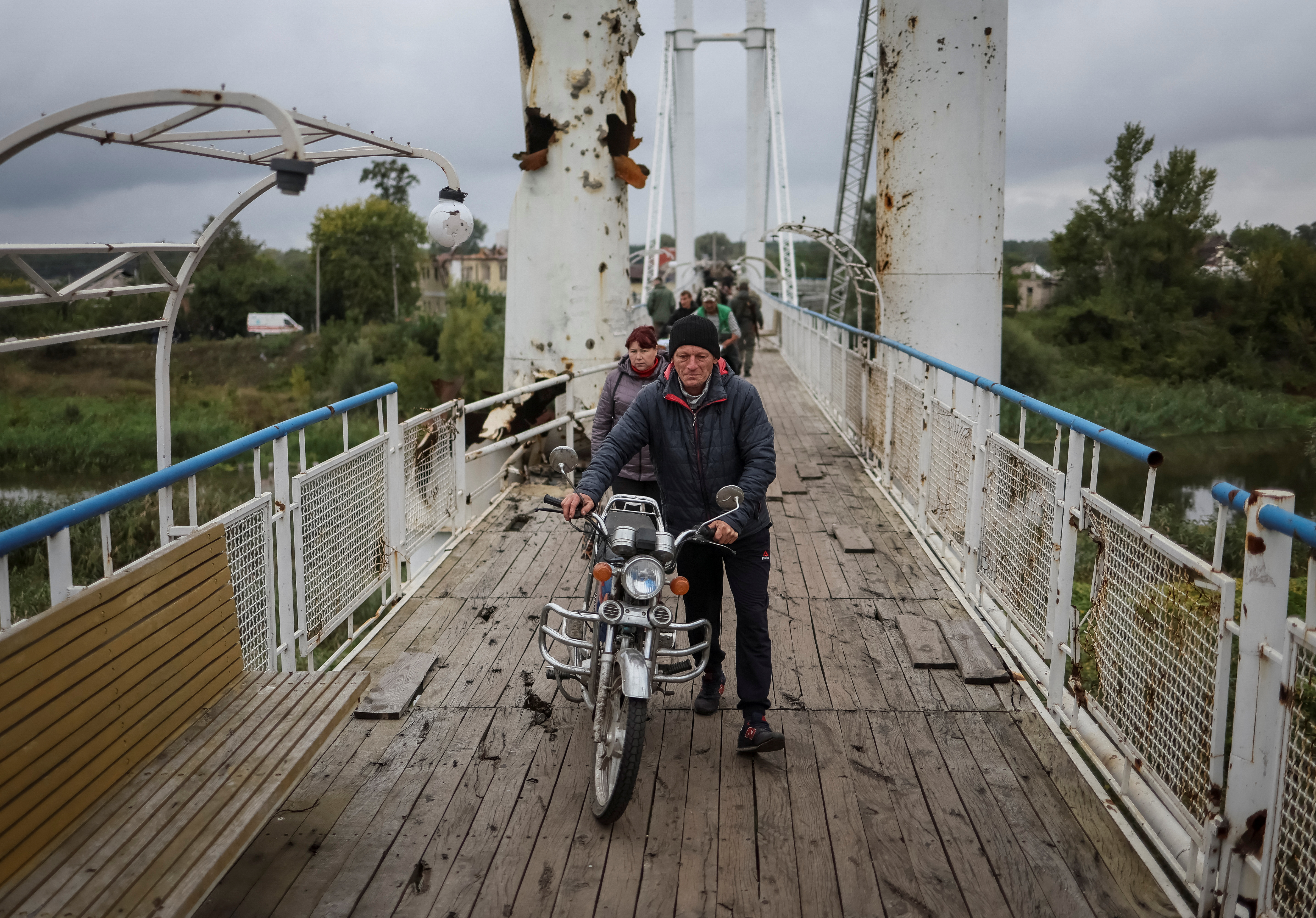 Ukrainian serviceman patrols at a damaged bridge in the town of Izium