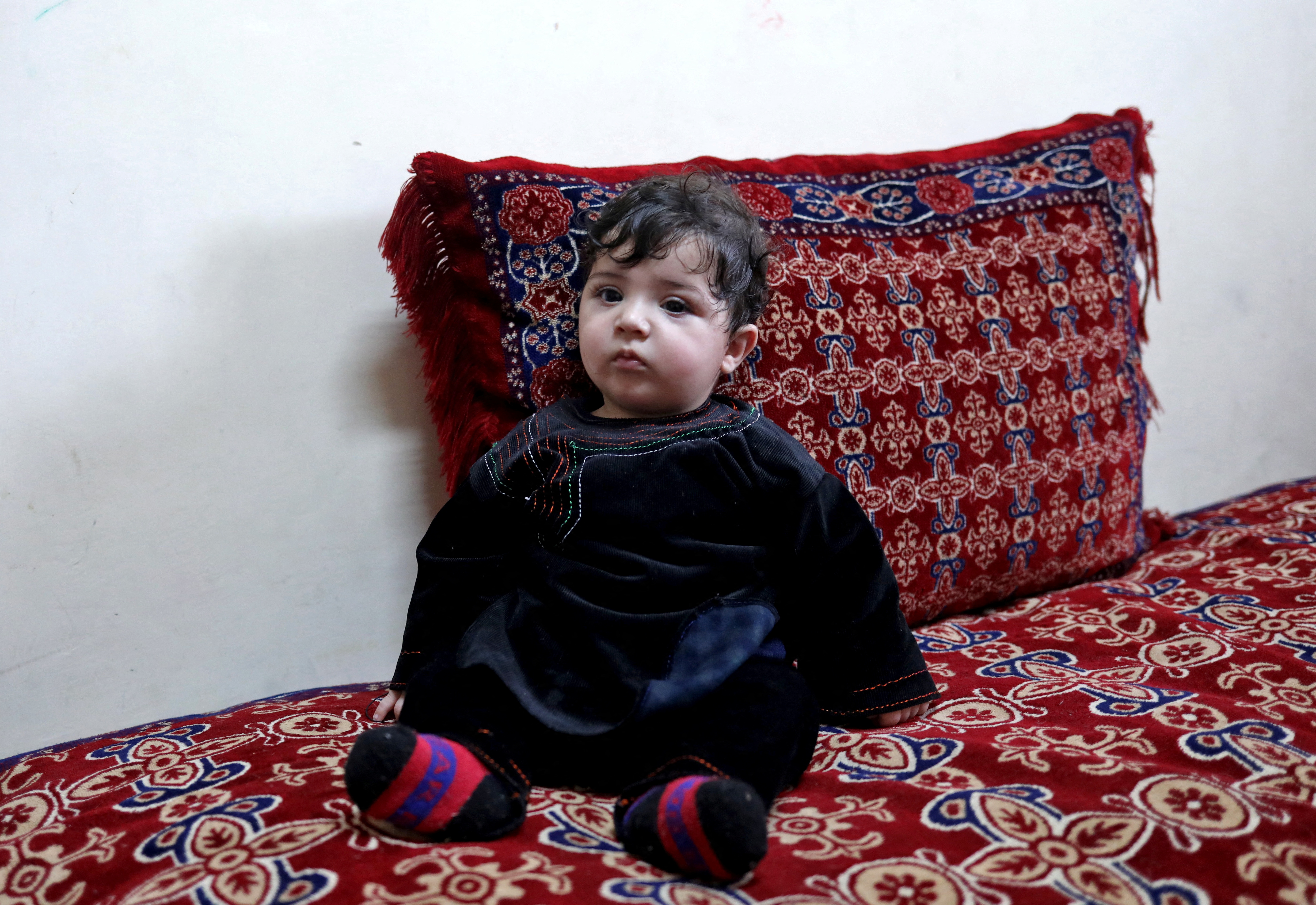 Baby Sohail Ahmadi sits inside the house of Hamid Safi in Kabul
