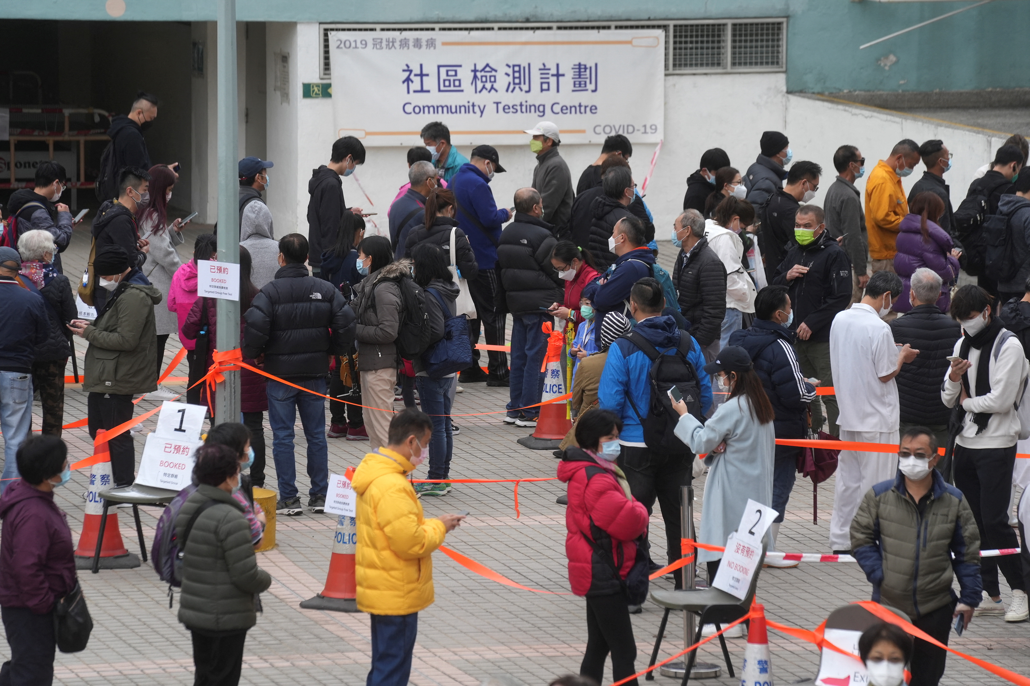 People wearing face masks queue at a community nucleic acid testing centre for the coronavirus disease (COVID-19) at Sha Tin district, in Hong Kong