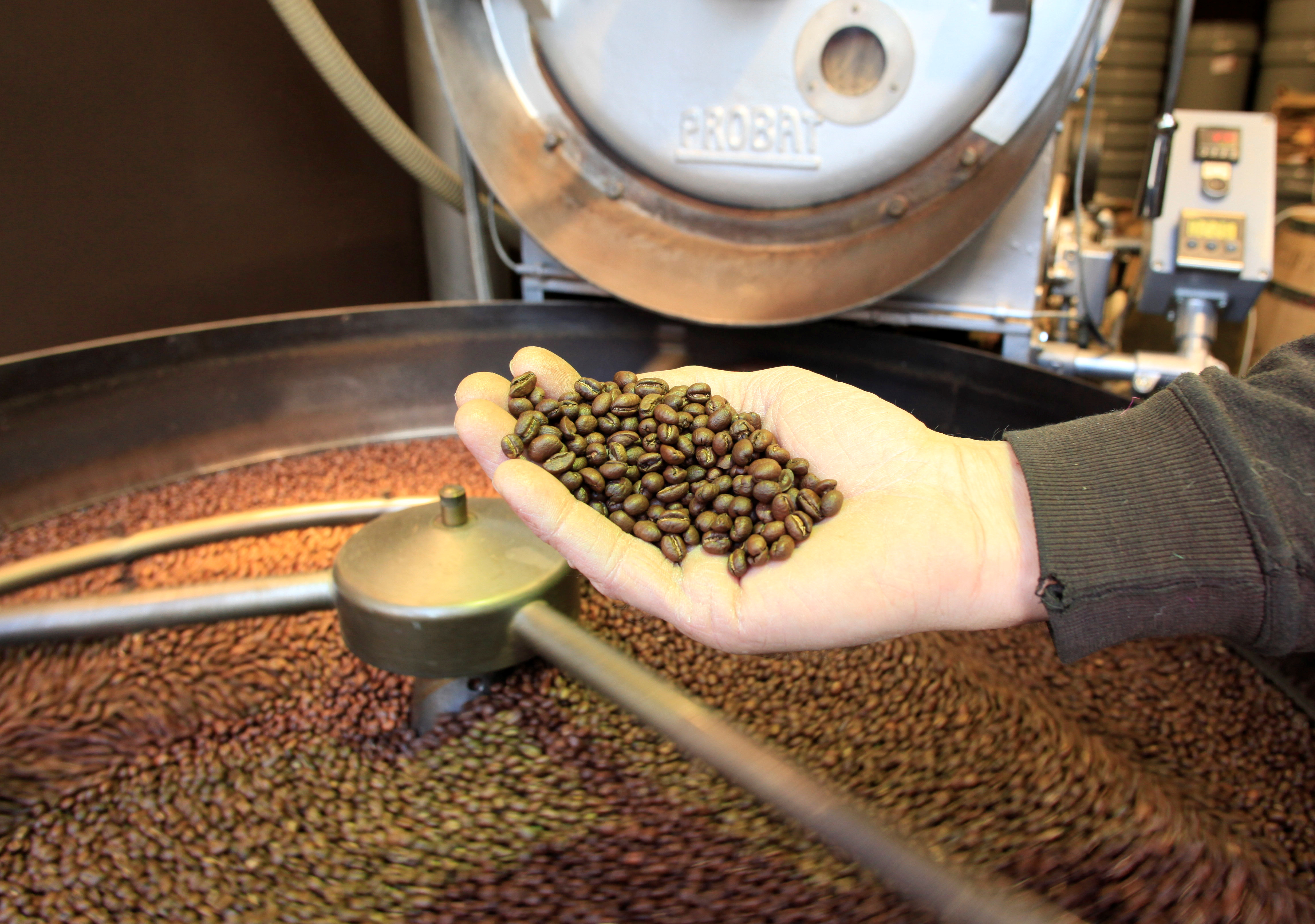 An employee checks freshly roasted coffee beans at H. Schwarzenbach coffee roastery in Zurich