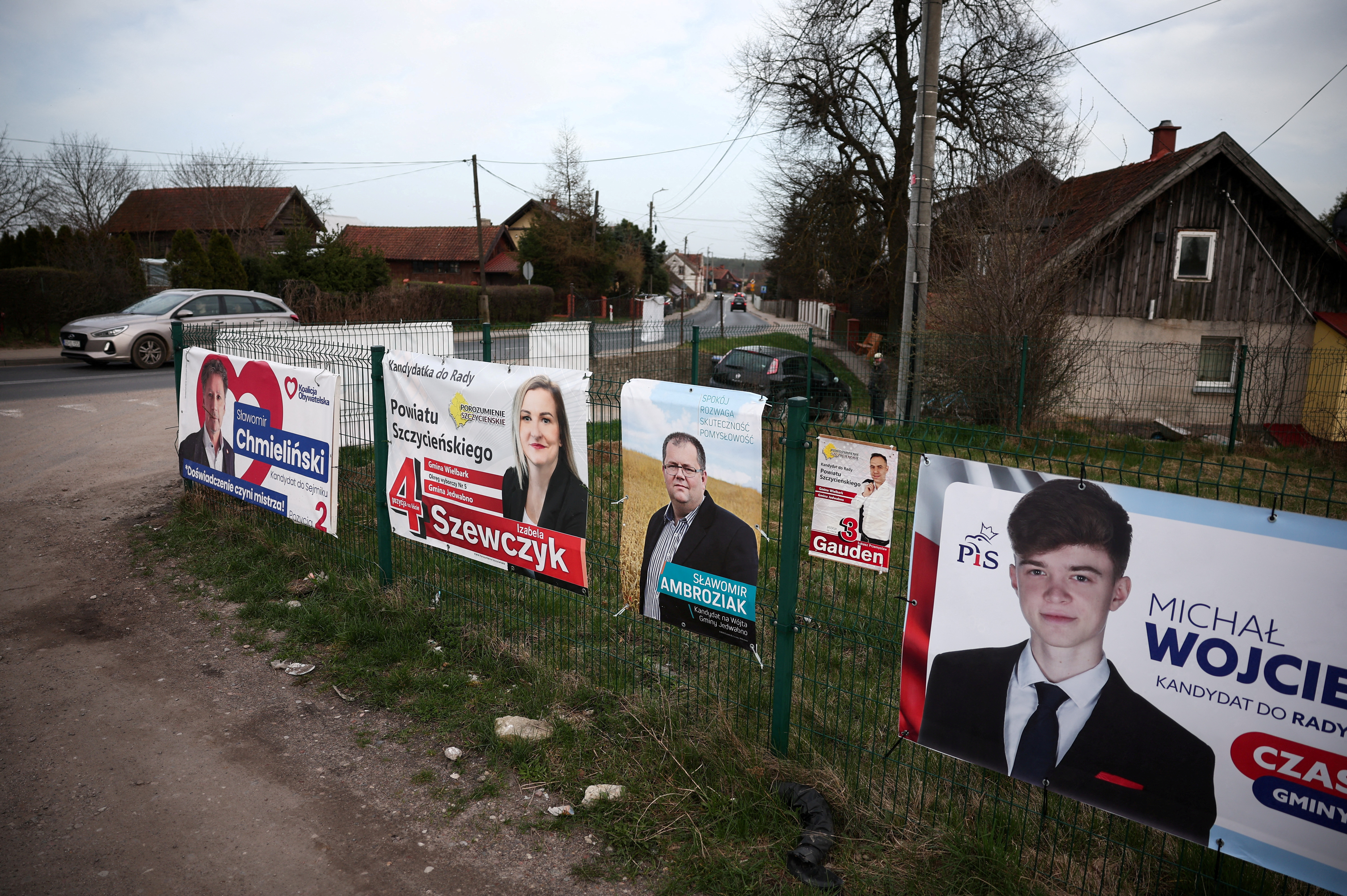 Election posters are seen hanging on the fence ahead of next weekend Polish local elections, in Jedwabno