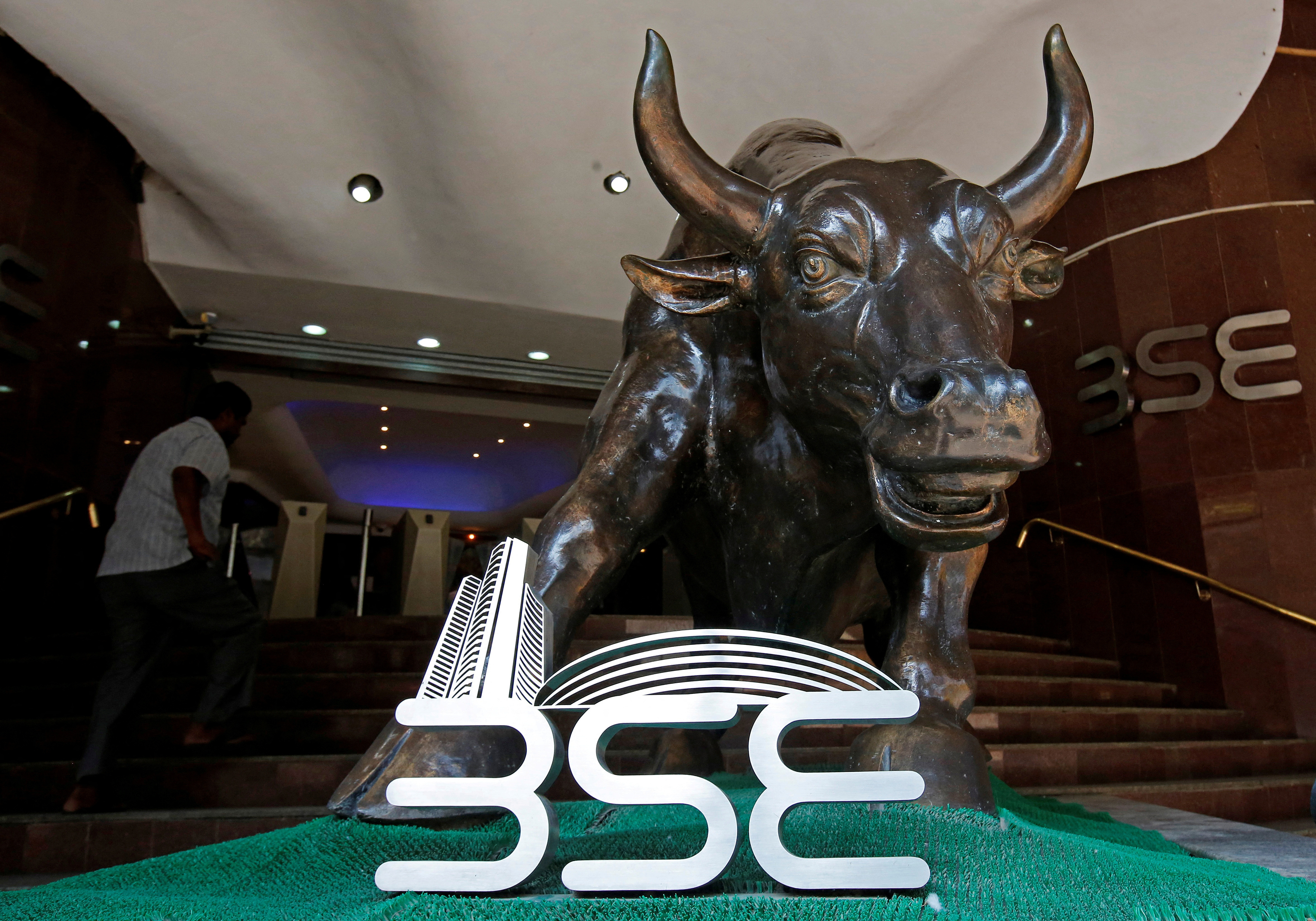 The Bombay Stock Exchange (BSE) logo is seen under a bull statue at the entrance of their building in Mumbai