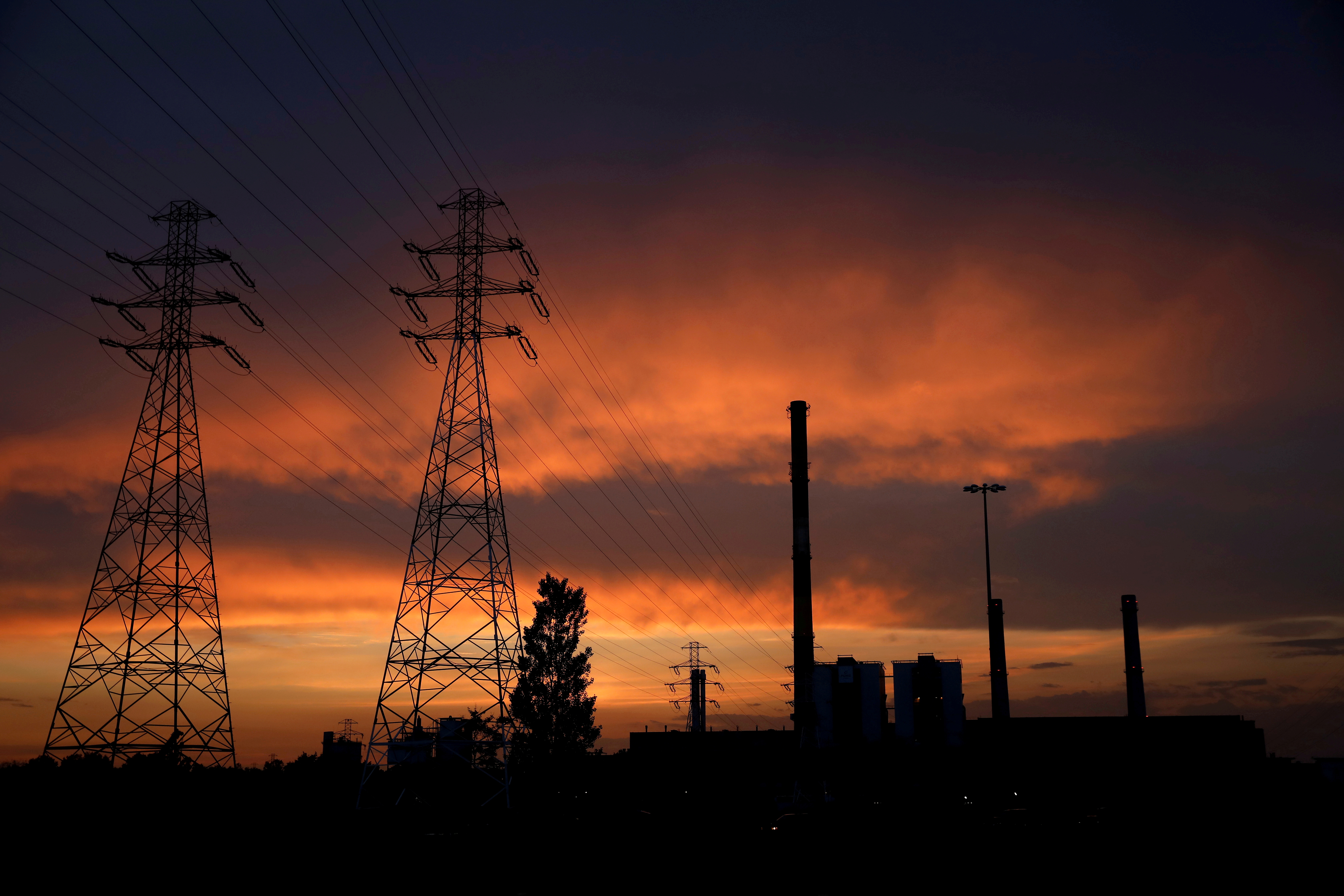 Electricity poles are pictured in front of the PGNiG Termika Zeran thermal power station after sunset in Warsaw, Poland June 19, 2019. REUTERS/Kacper Pempel