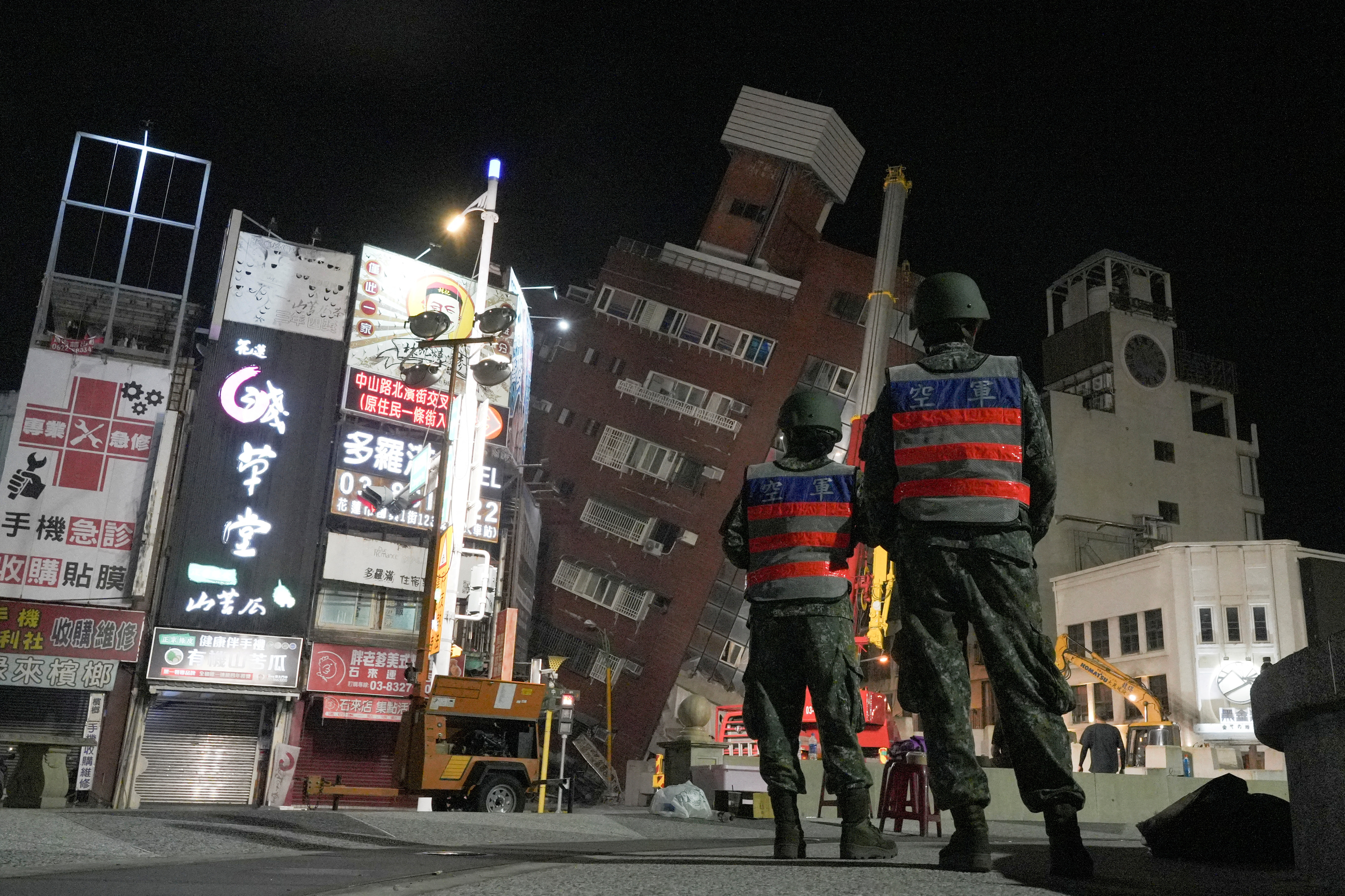 Soldiers stand near the site where a building collapsed, following an earthquake, in Hualien