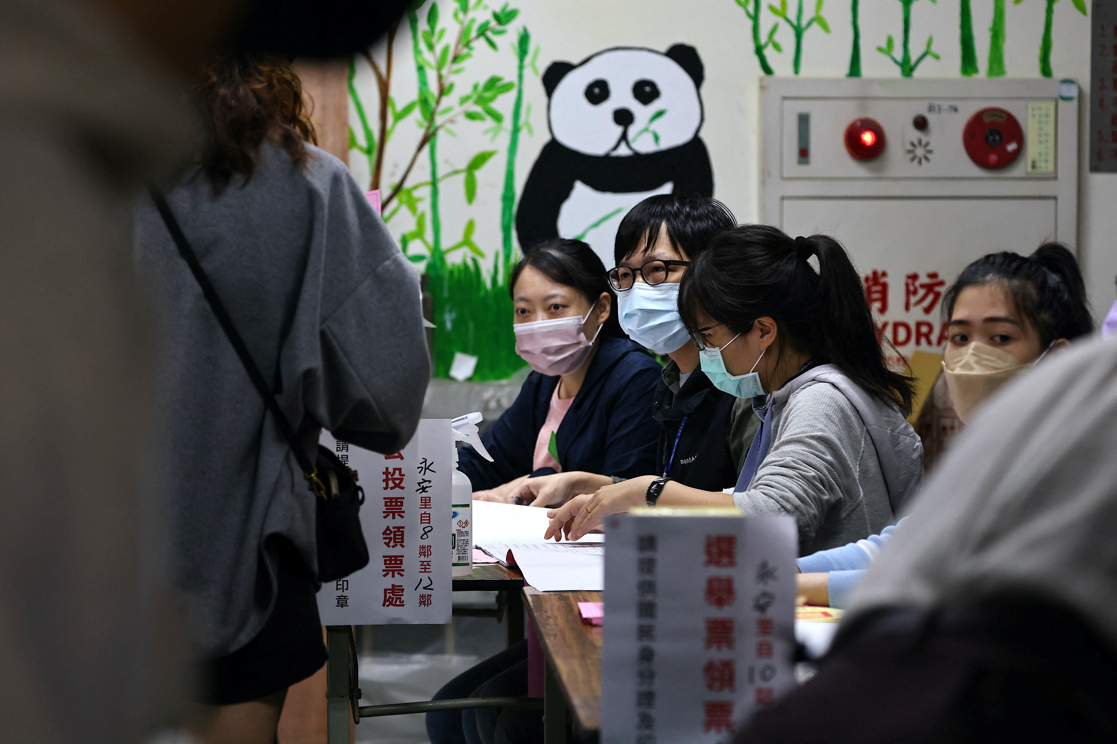 People line up to cast their votes on election day in Taipei