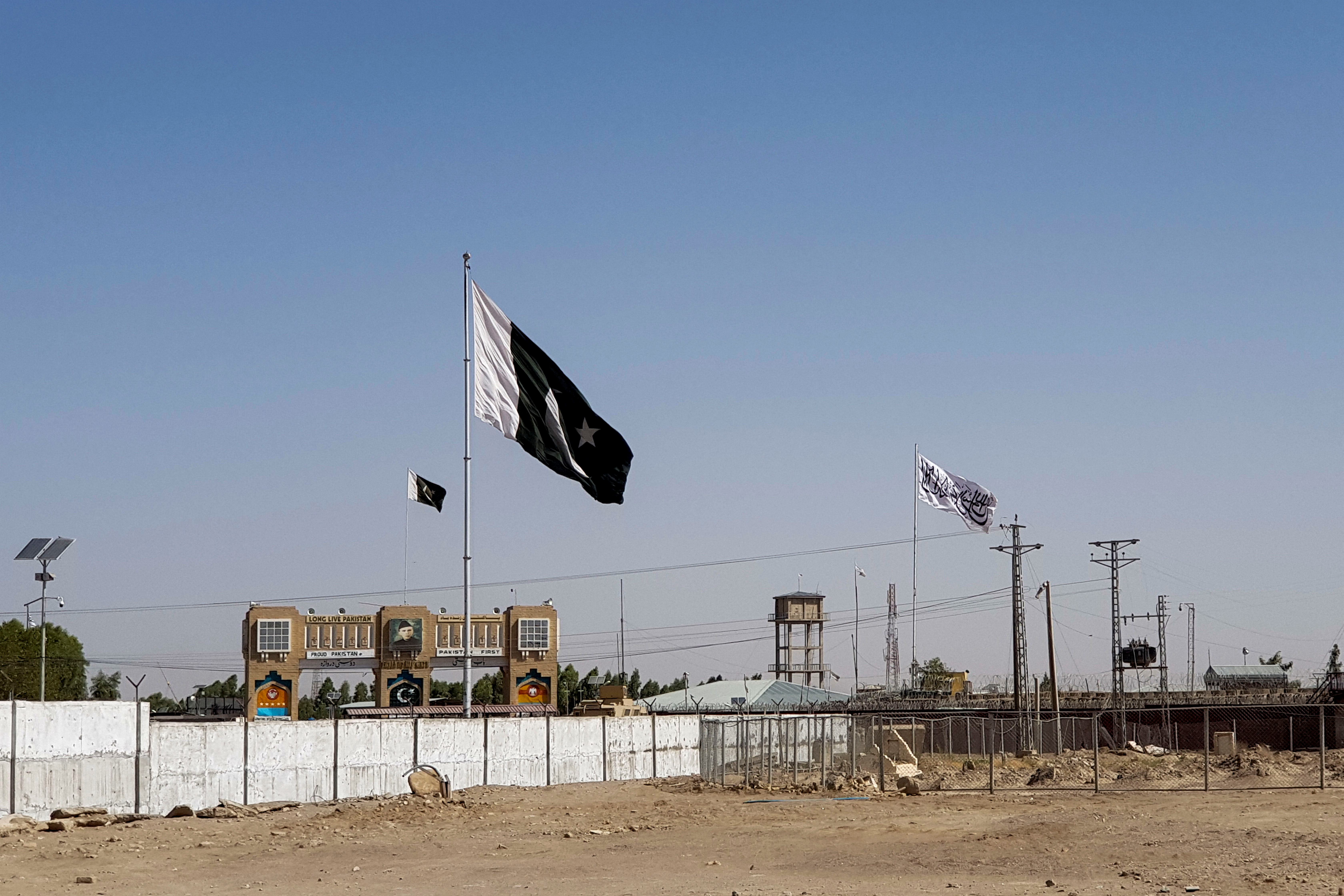 General view of the Pakistan's flag and the Taliban's flag in the background as seen from the Friendship Gate crossing point in the Pakistan-Afghanistan border town of Chaman