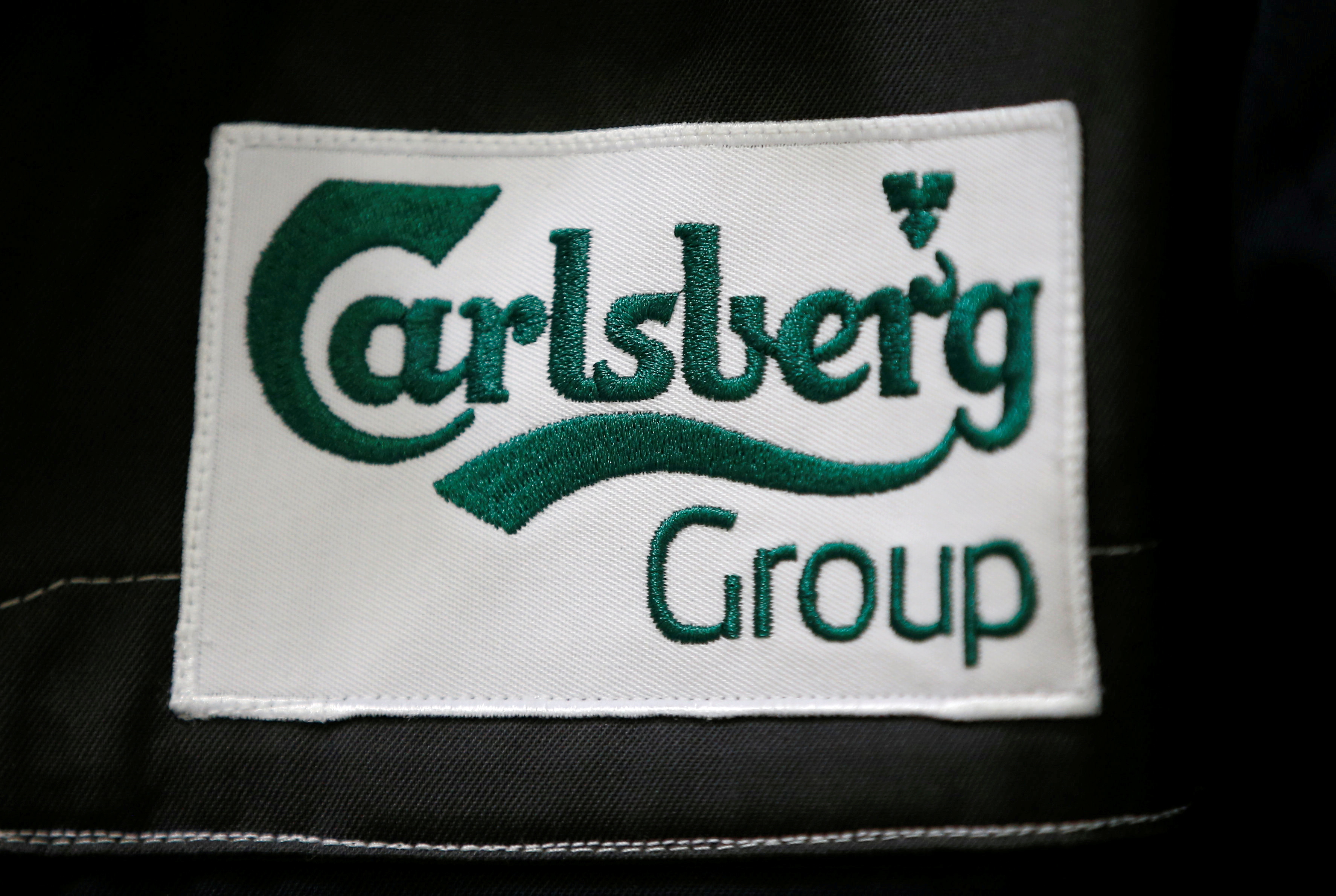 The Calsberg's logo is seen on the jacket of an employee at the development center of the Carlsberg group at the K2 Kronenbourg beer brewery in Obernai