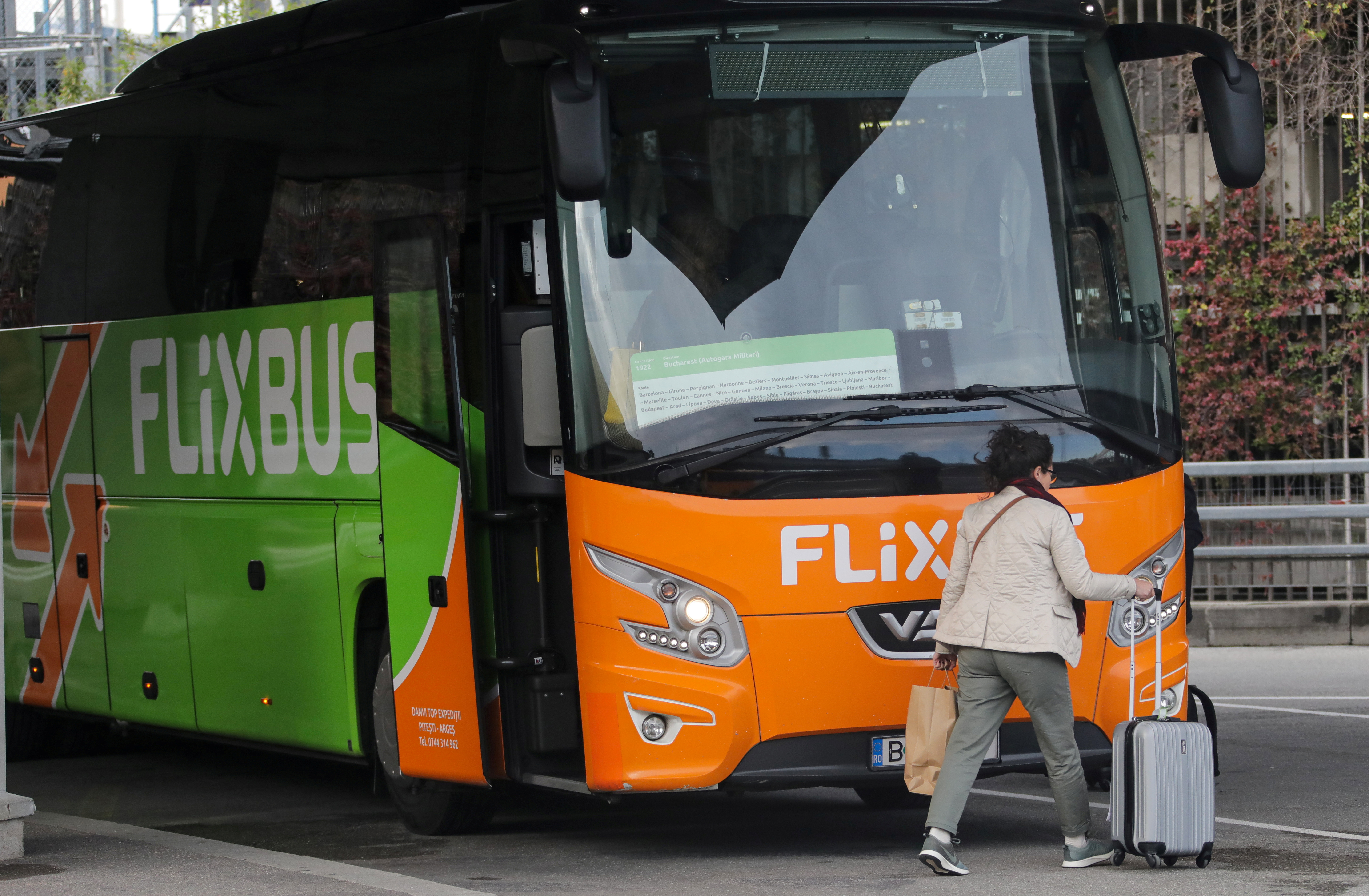 A passenger walks by a FlixBus bus at Nice international airport