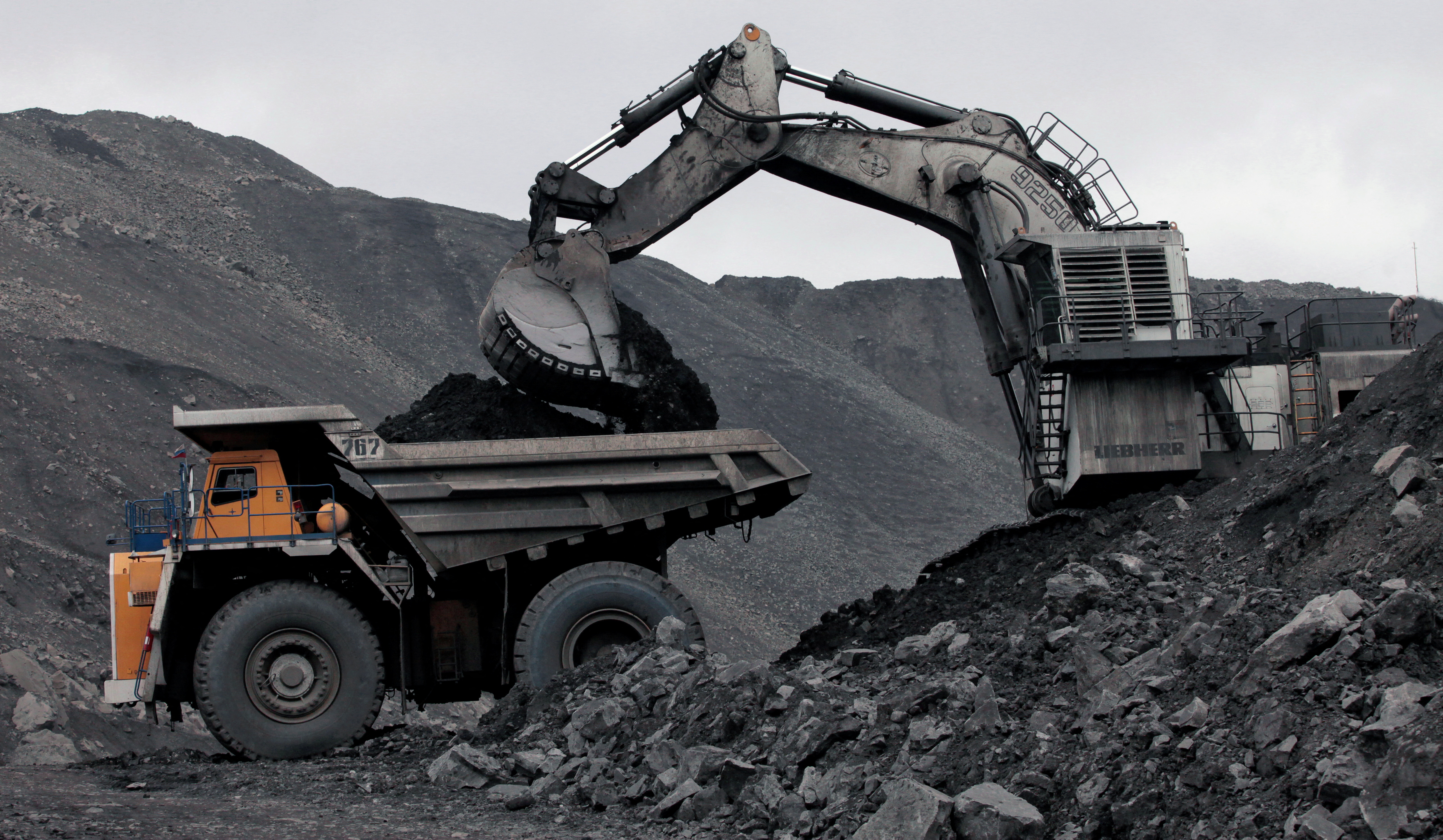A machine loads dump-body truck with coal at Chernigovsky opencast colliery in Kemerovo region, Siberia, Russia