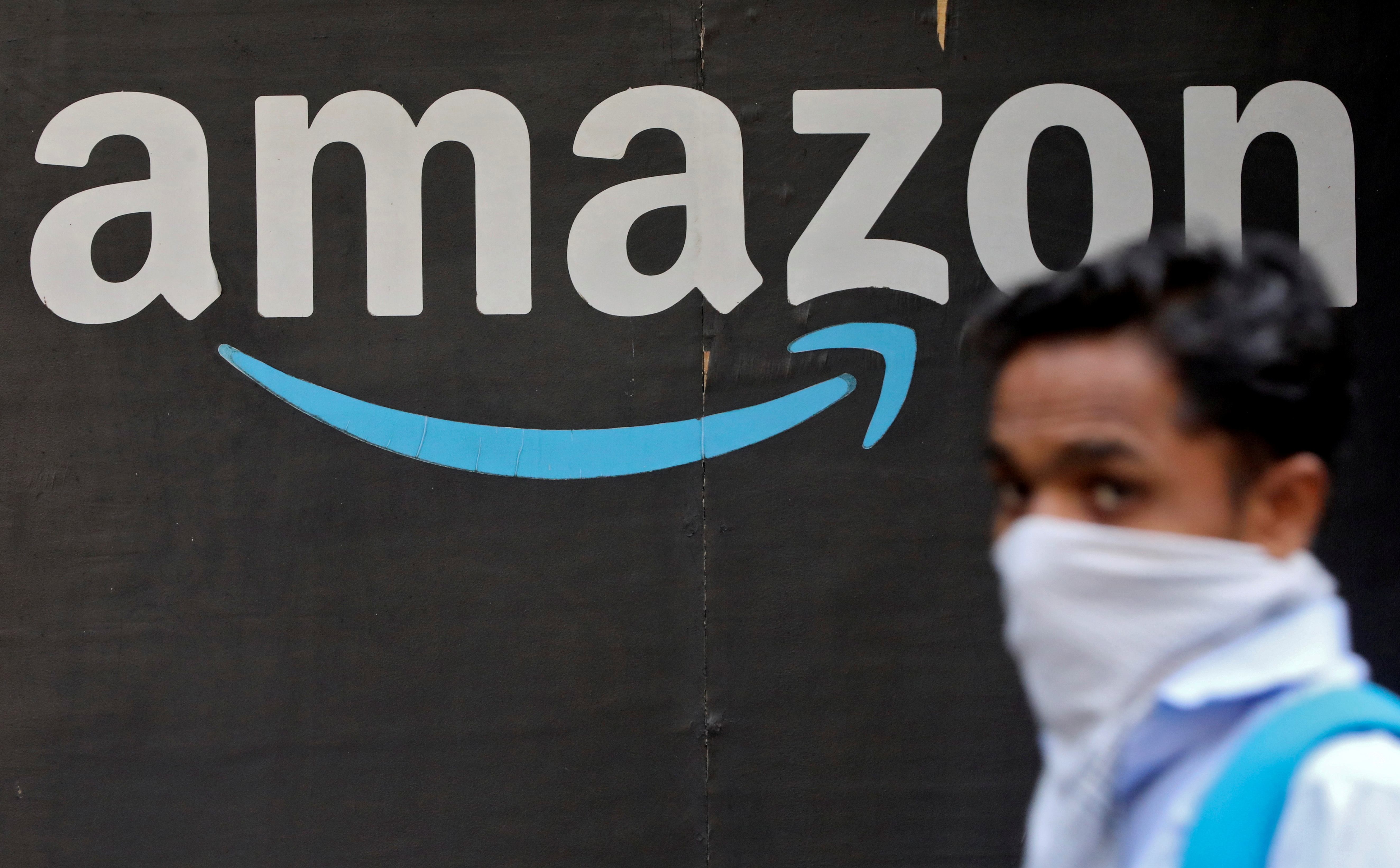 A man walks past an Amazon logo outside the company's collection point in Mumbai