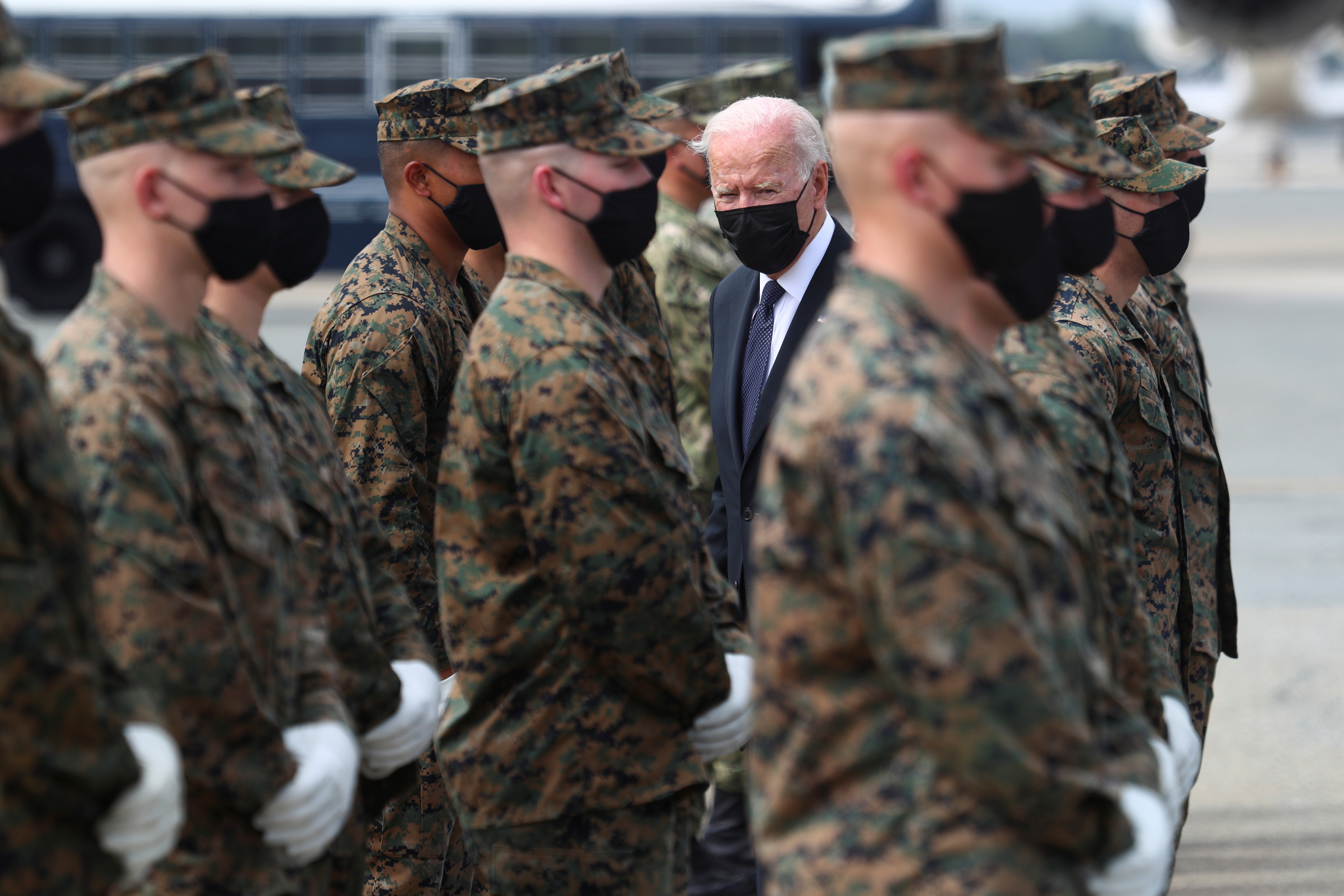 U.S. President Joe Biden hands challenge coins to the members of the U.S. Marine Corps Honor Guard before boarding Air Force One