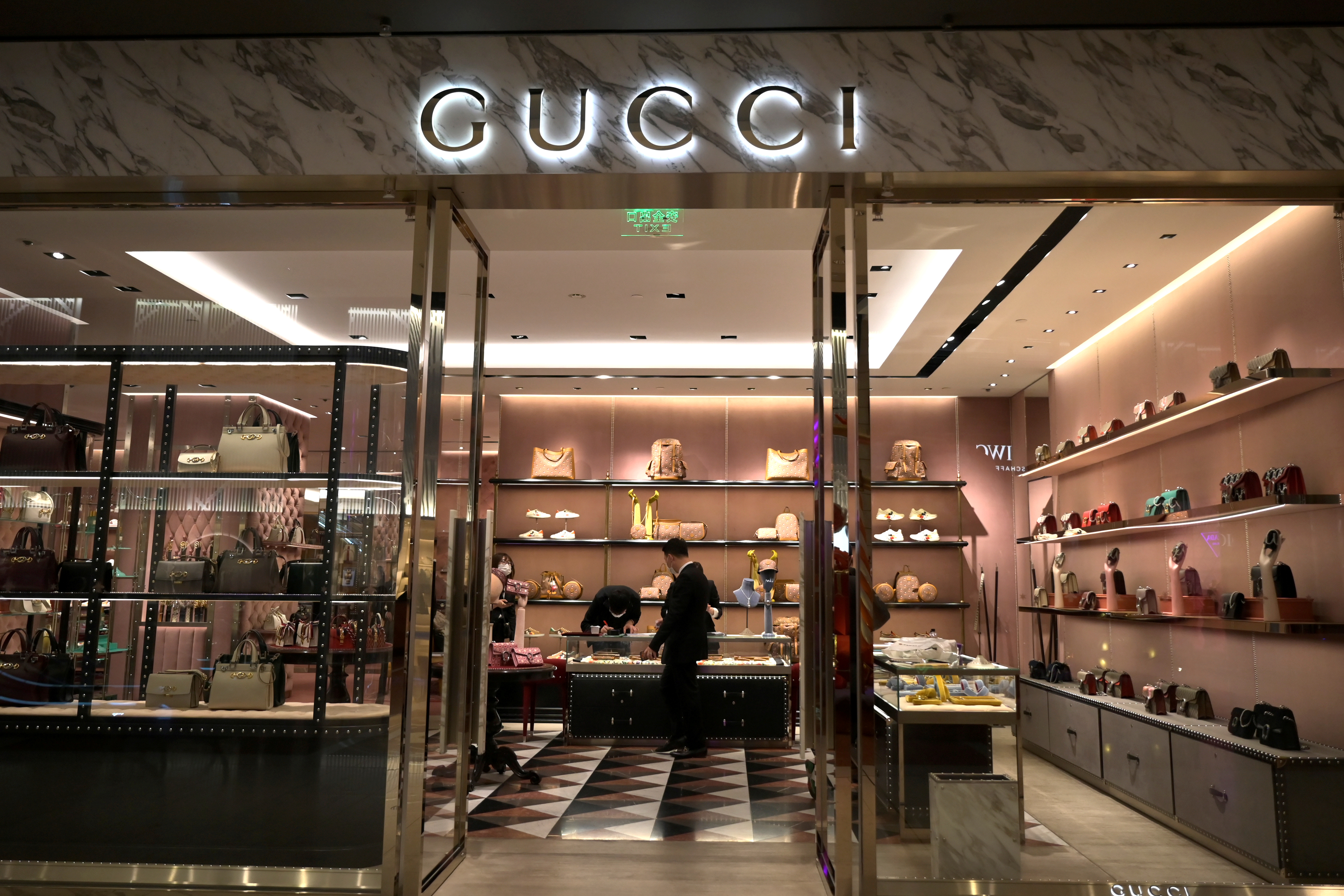 Staff members wearing face masks are seen inside a store of an Italian luxury brand Gucci at a shopping mall, as the country is hit by an outbreak of the novel coronavirus, in Beijing