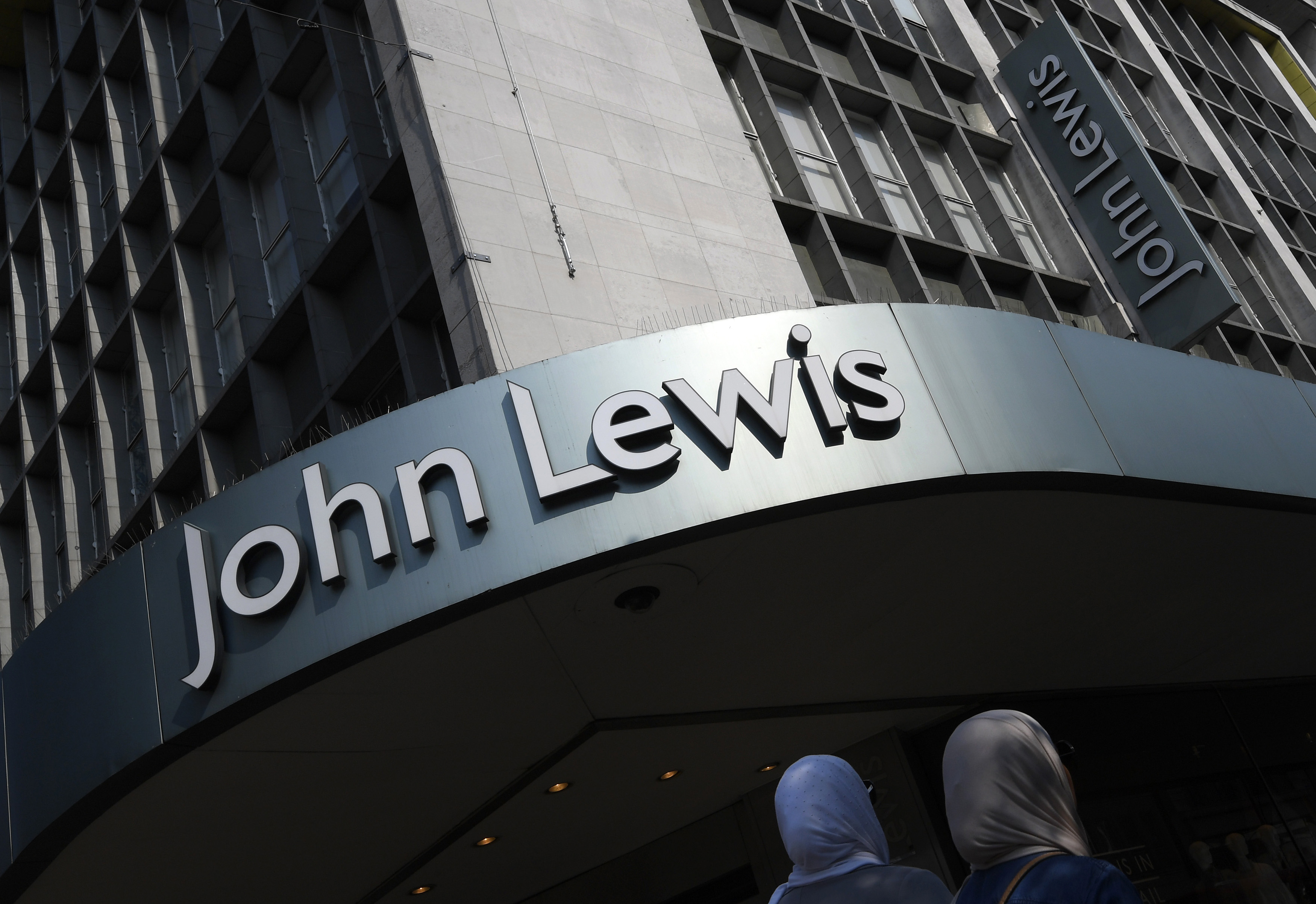 Shoppers pass a branch of John Lewis in London, Britain