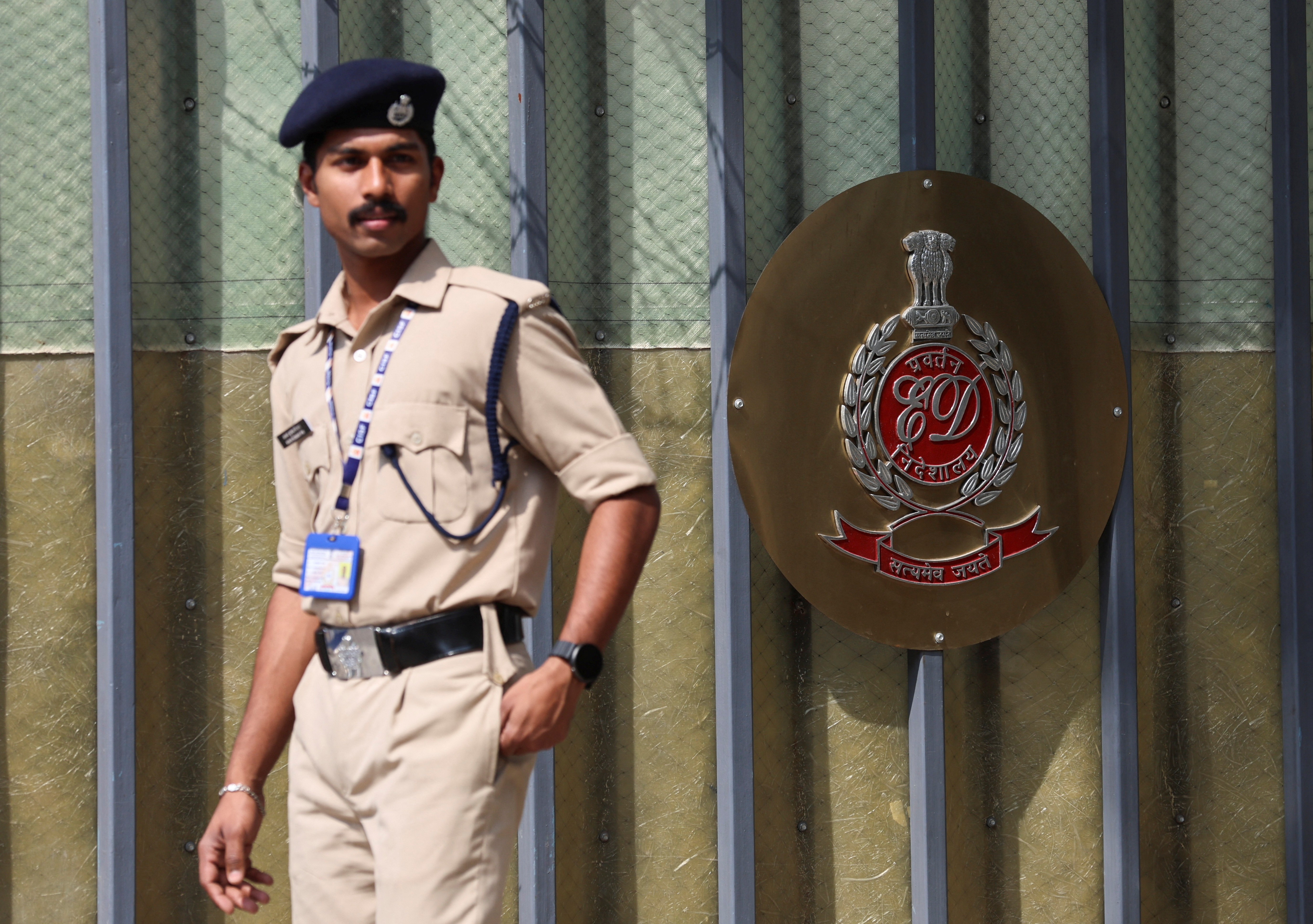 A security personnel walks past a gate of the office of Directorate of Enforcement in New Delhi
