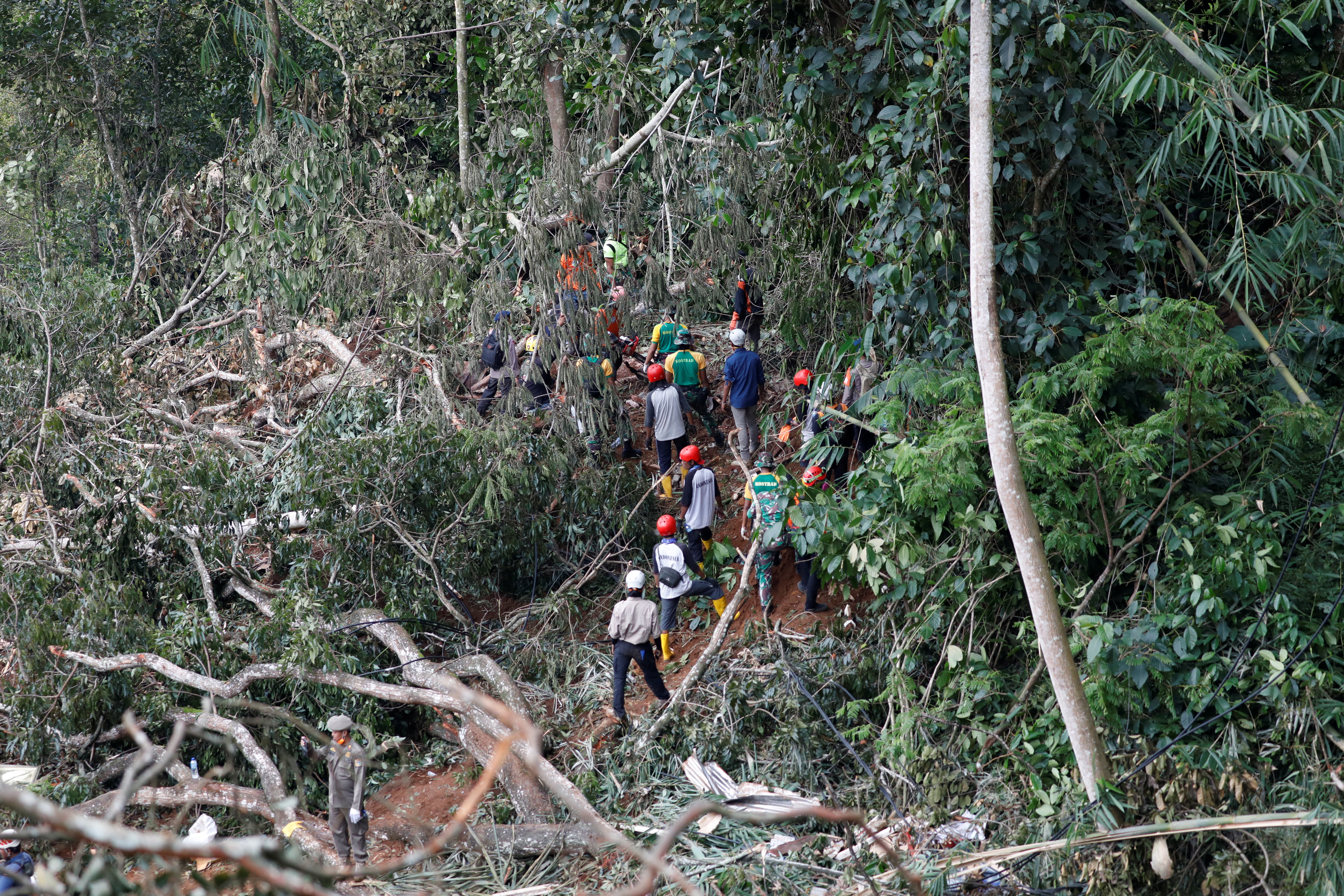An Indonesian rescue team searches for victims from the site of a landslide caused by an earthquake in Cianjur