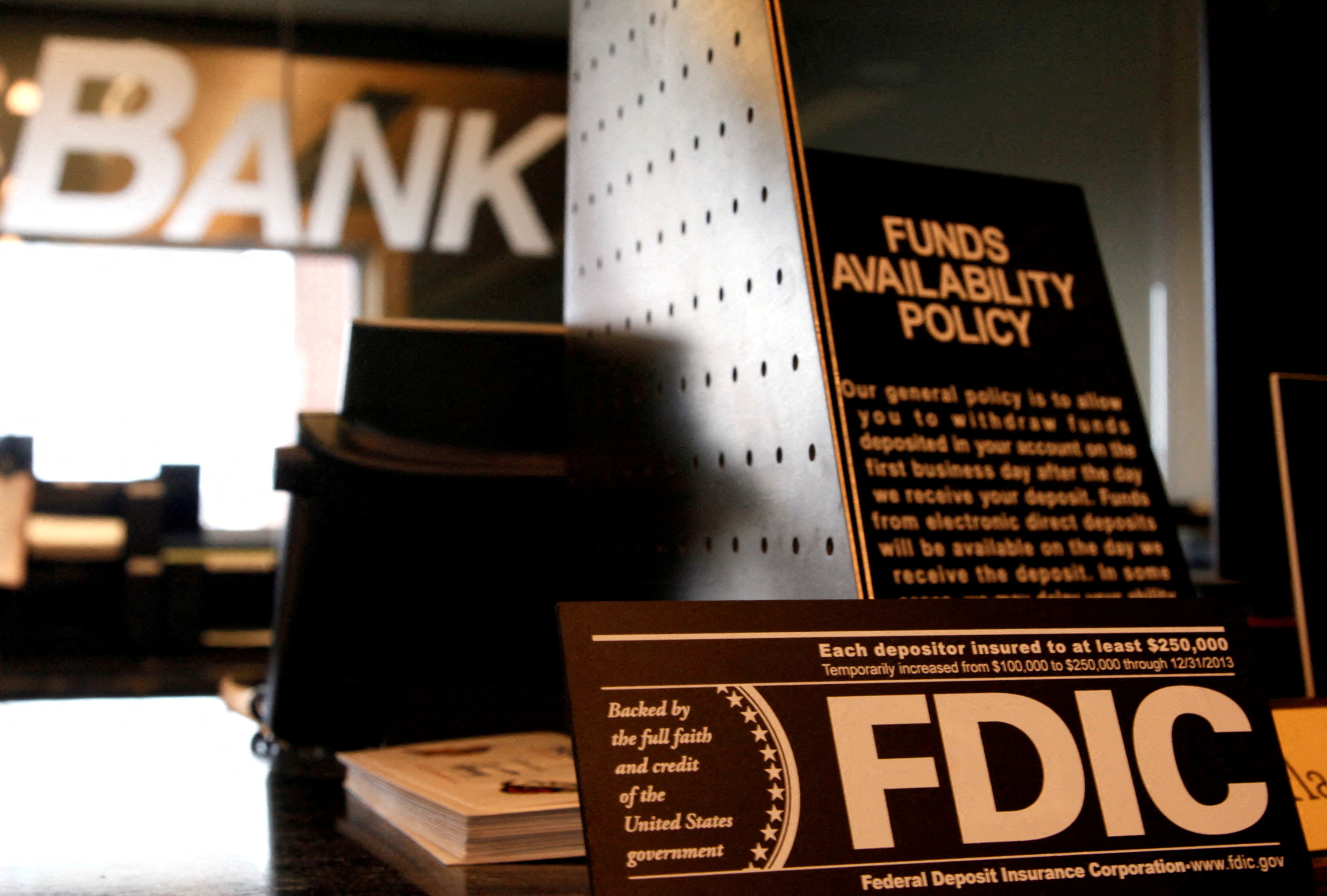 FILE PHOTO: Signs explaining the Federal Deposit Insurance Corporation (FDIC) and other banking policies are seen on a bank counter in Westminster