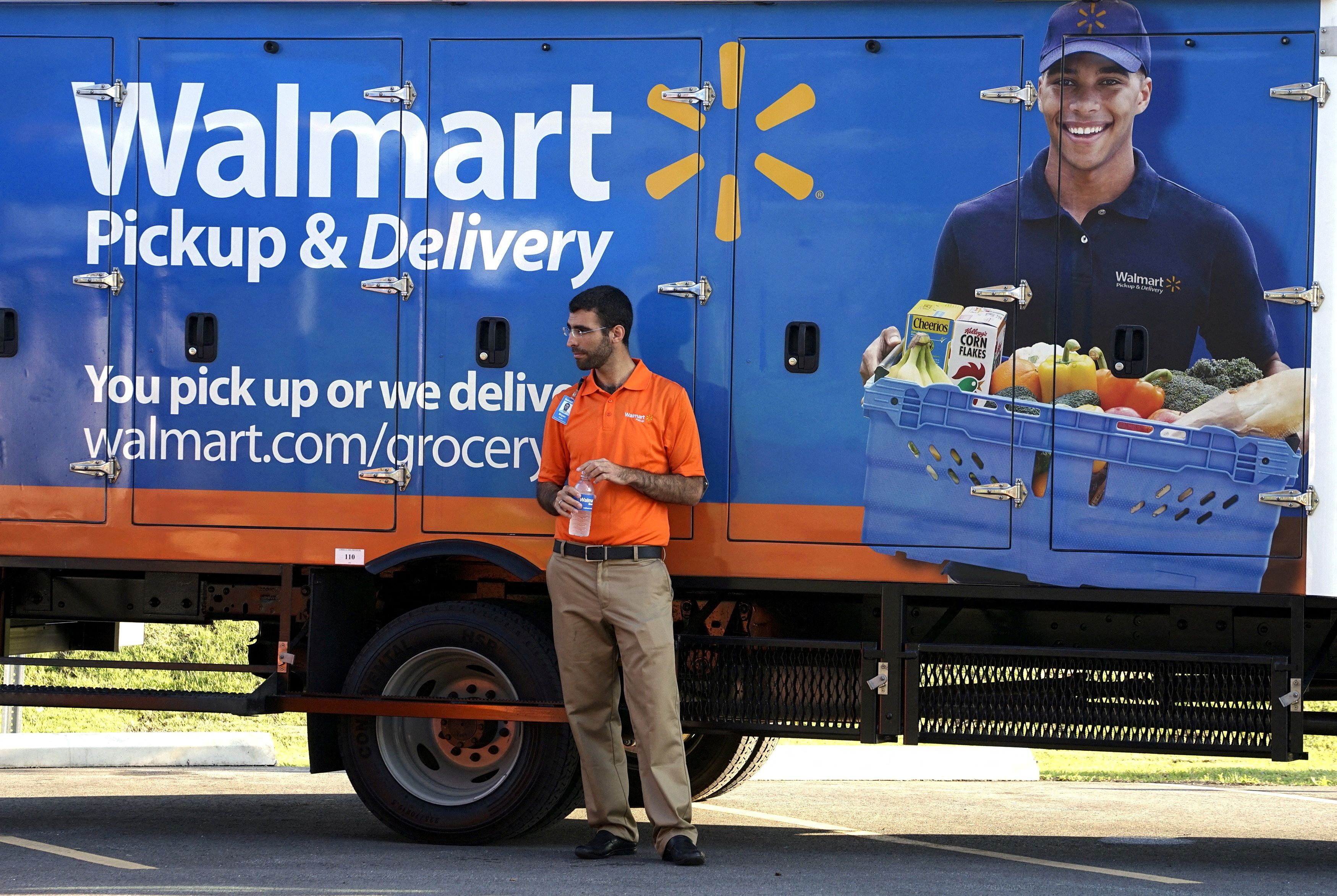 A Wal-Mart Pickup-Grocery employee waits next to a truck at a test store in Bentonville