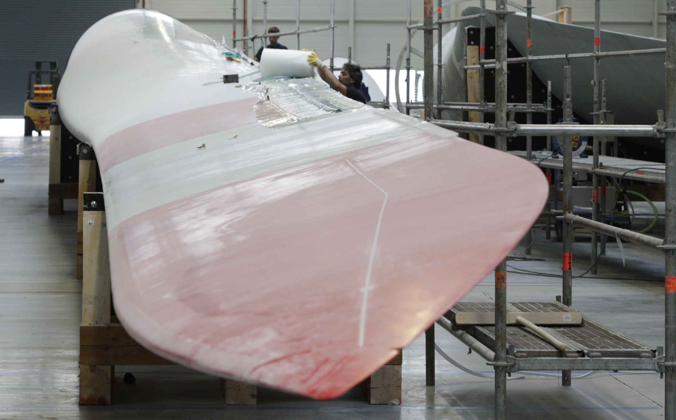 Engineer works on wing at the Nordex wind turbine factory hall in Rostock