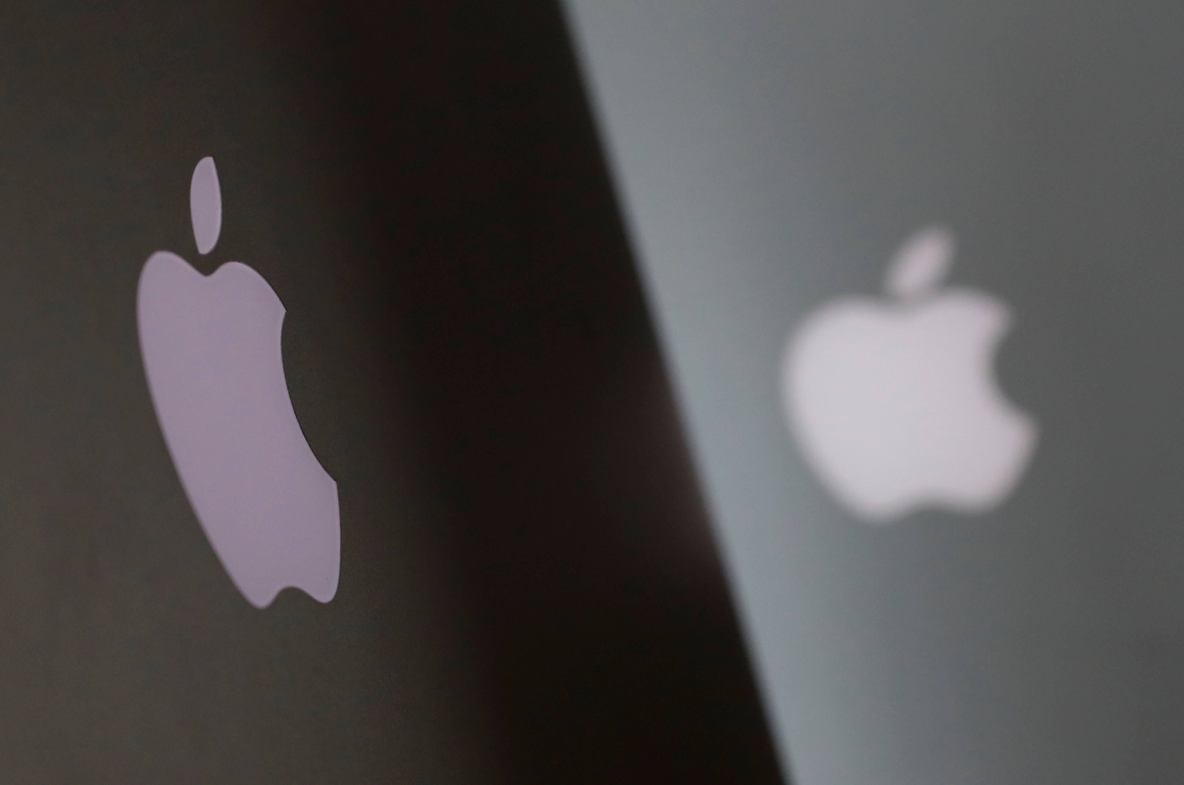 Apple company logos are seen as two MacBooks stand next to each other in an office in Vienna