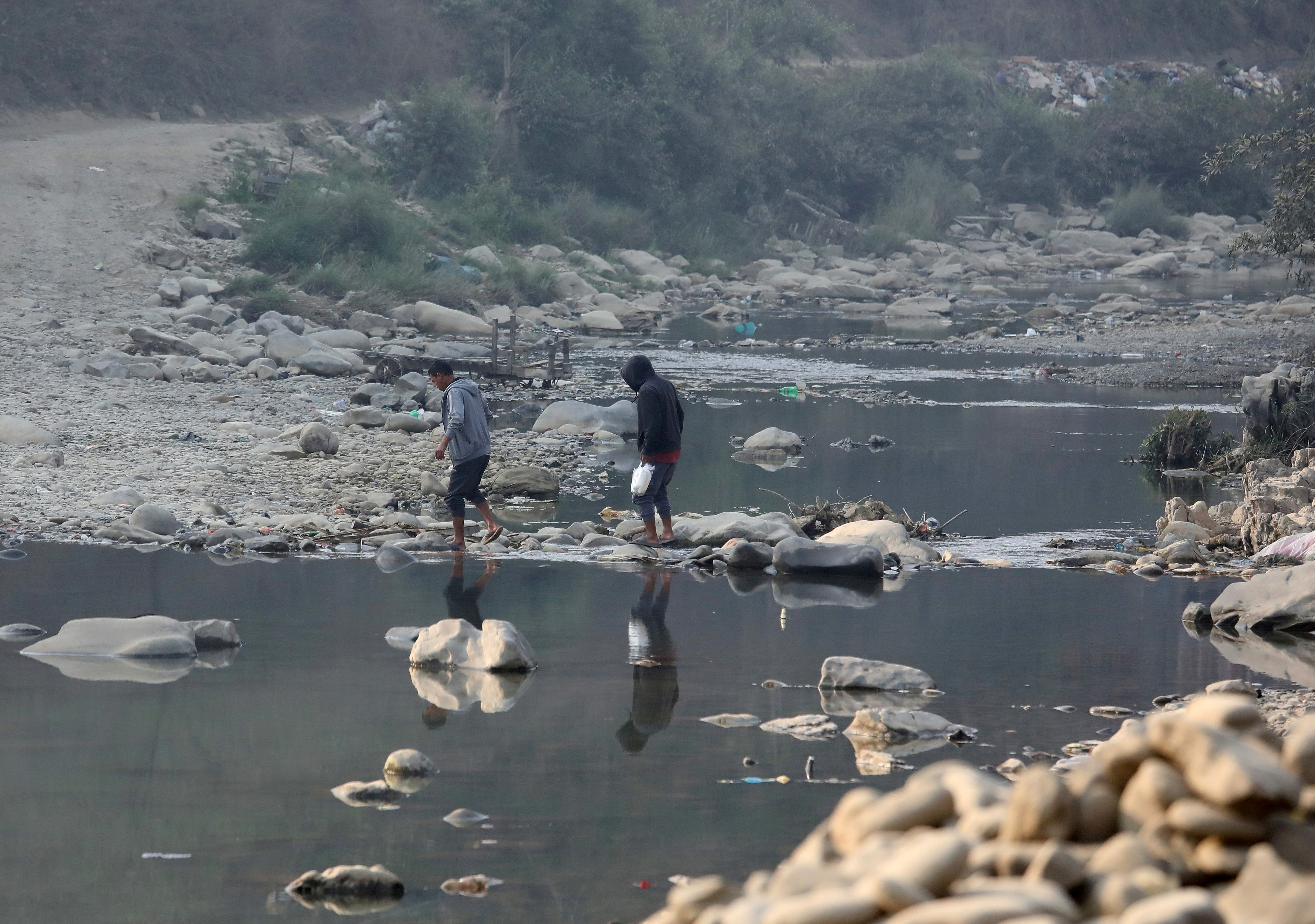 People cross the Tiau river which marks the India-Myanmar border at Zokhawthar village
