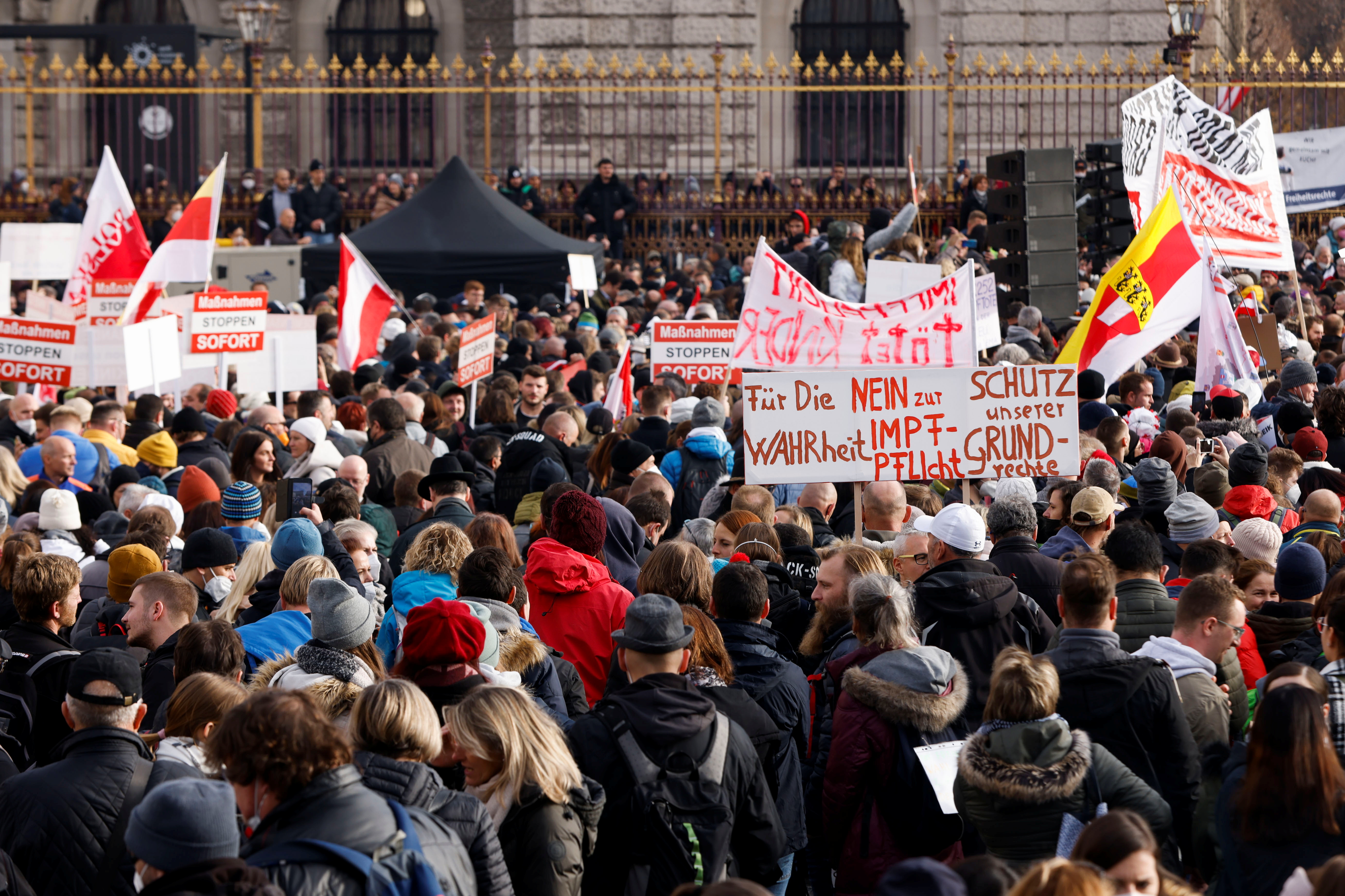 Demonstranci trzymają flagi i plakaty, gdy zbierają się, by zaprotestować przeciwko środkom związanym z koronawirusem (COVID-19) w Wiedniu, Austria, 20 listopada 2021 r. Na plakacie czytamy: „Prawdę mówiąc, nie dla obowiązkowych szczepień, chroń nasze prawa”. REUTERS/Leonhard Foeger